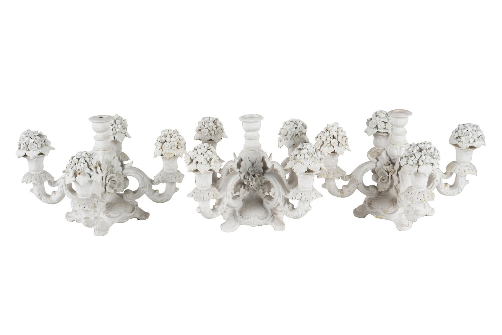 THREE ITALIAN BISQUE PORCELAIN CANDELABRA: 20th century each marked to underside "Italy", each with five lights, together with 13 floral nozzle covers each 12 inches diameter; 8 1/2 inches high