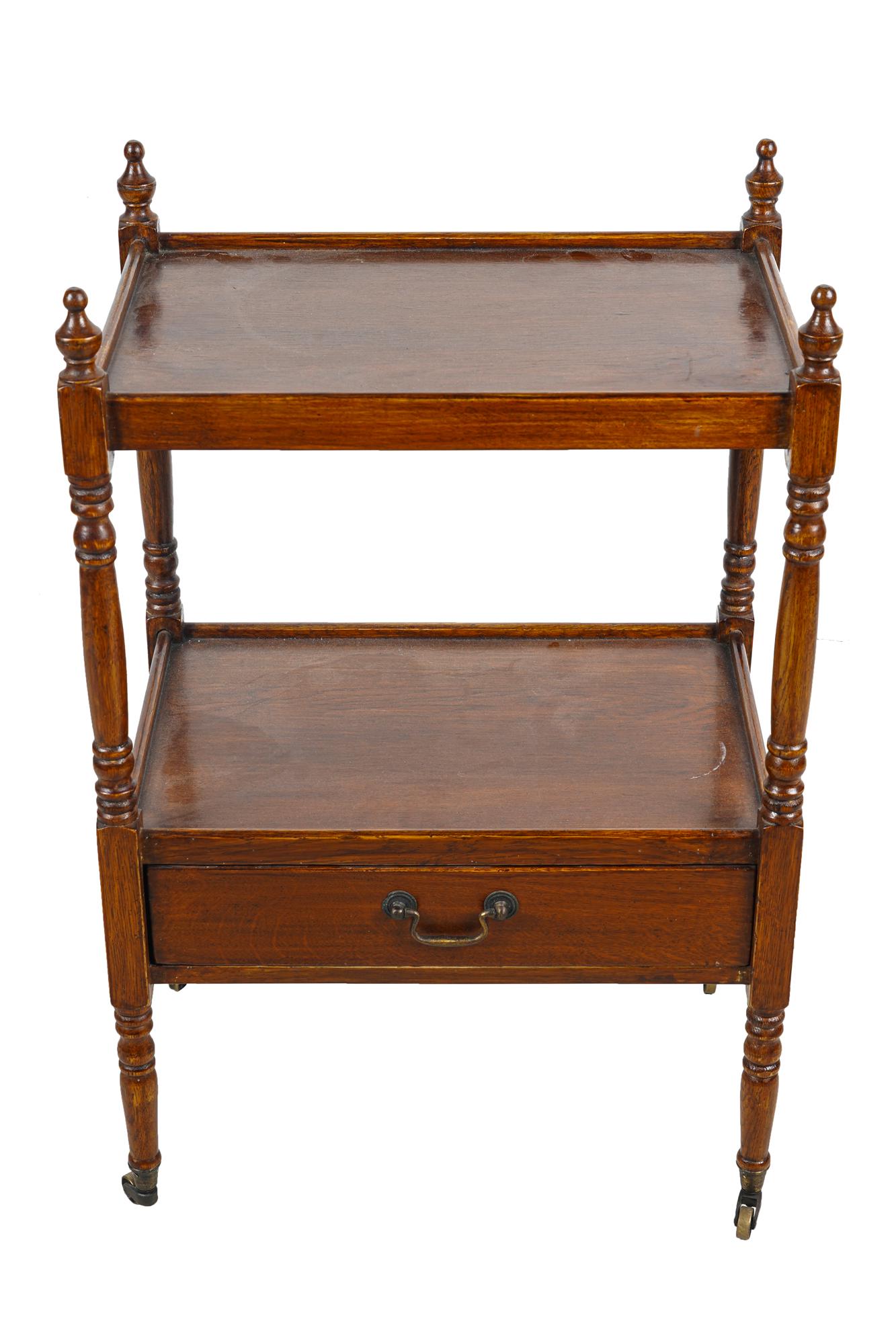 GEORGIAN STYLE MAHOGANY ETAGERE: with two shelves and a drawer, raised on metal casters Provenance: A Michael Smith installation 19 3/4 inches wide; 14 inches deep; 30 inches high