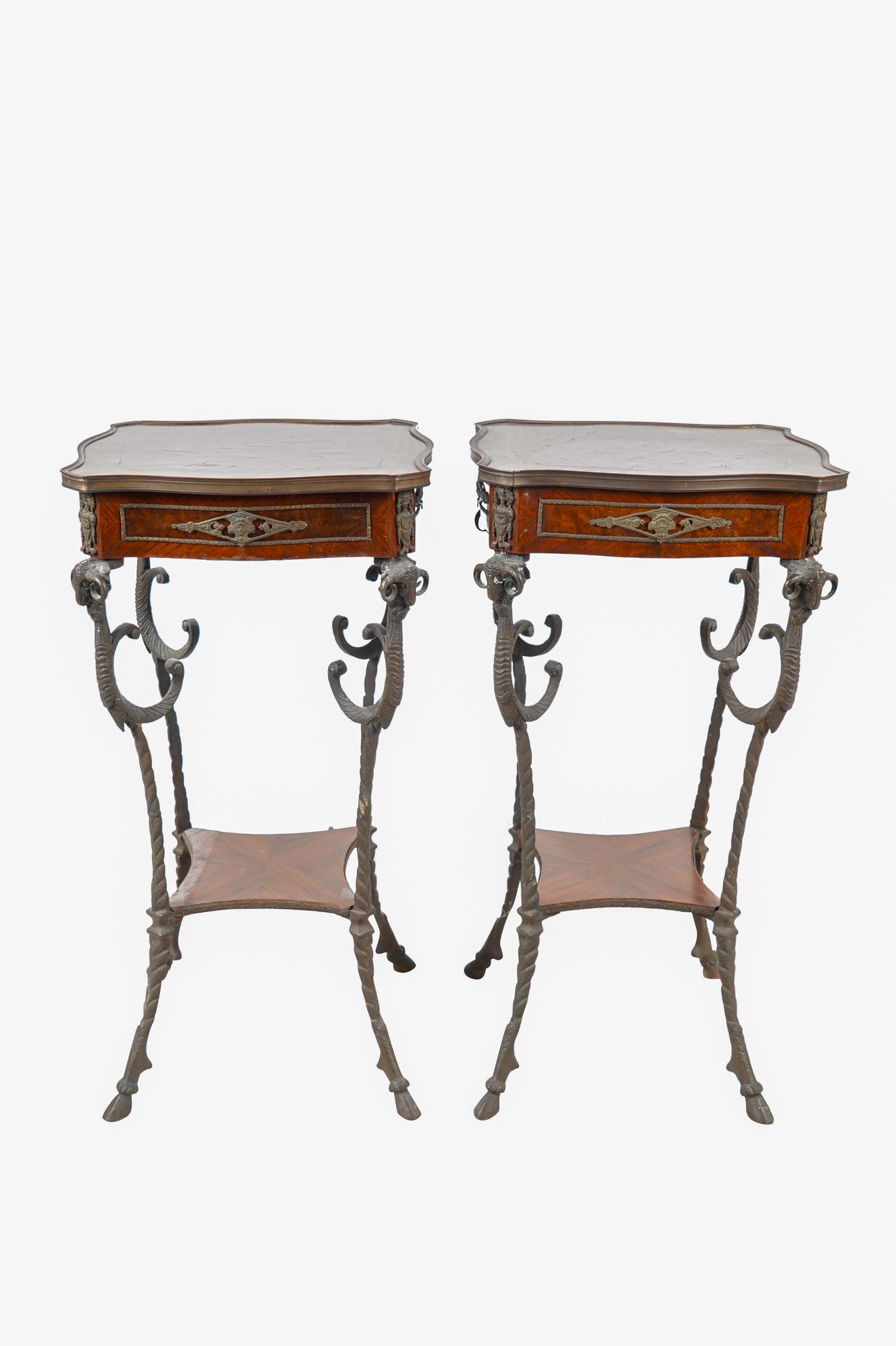PAIR OF FRENCH BRONZE & MAHOGANY TABLES: with cloven feet and ram's head decorations Condition: tables wobble; minor cracks to wood tops 15 inches square; 29 inches high