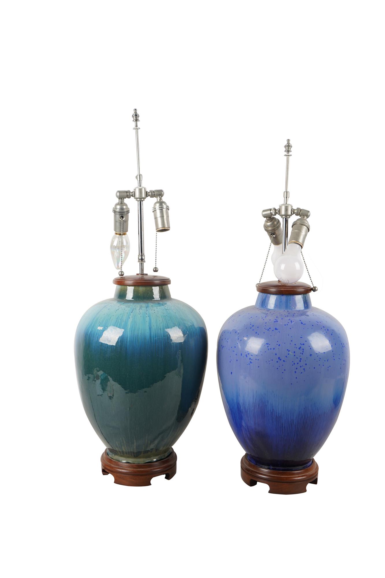 TWO BLUE-GLAZED JAR-FORM TABLE LAMPS: with variation in color Condition: Both jars in good condition, no visible cracks or repairs. Provenance: A Michael Smith installation Each measuring 30 inches total height. 18 inches to top of jar