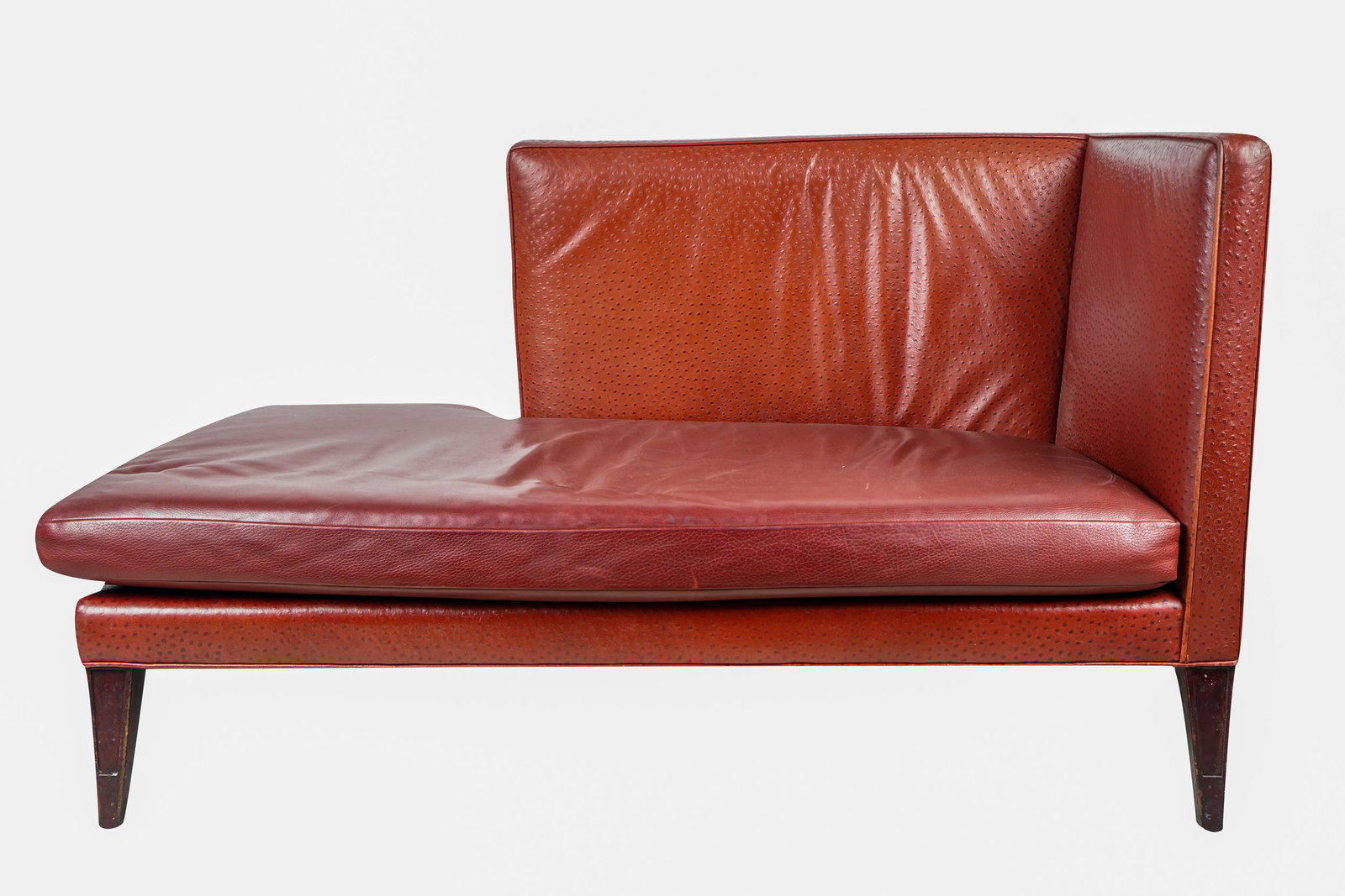 CHAISE LOUNGE: with faux ostrich upholstery and removable leather cushion Condition: with areas of discoloration to corners of leather and nicks to feet 29 inches wide; 61 inches deep; 35 inches high