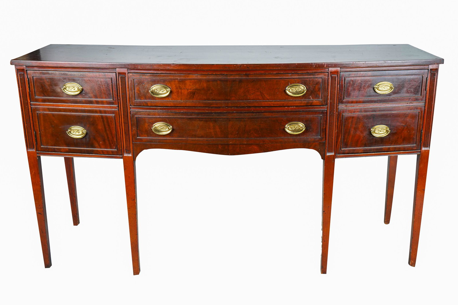 SHERATON-STYLE MAHOGANY SIDEBOARD: 20th century with two drawers flanked on each side by a hinged door each disguised as two drawers Condition: with nicks to molding and throughout. A one-inch diameter on front edge of top - 66 inches 