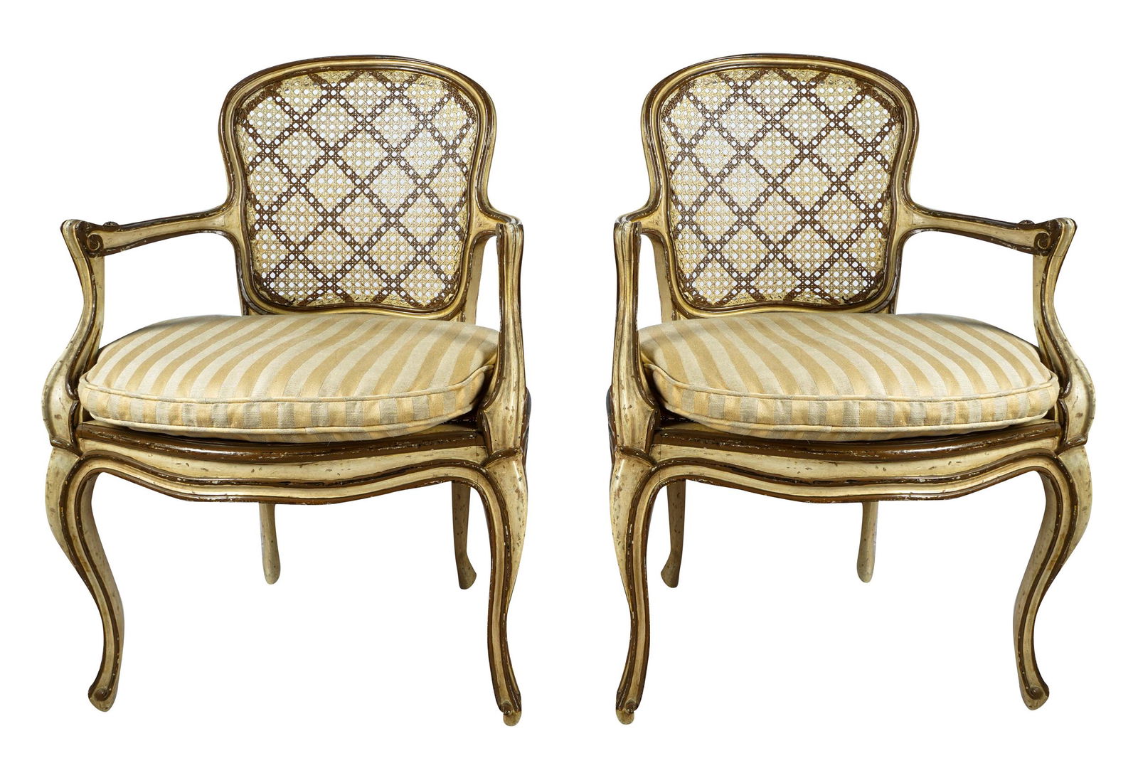 PAIR OF ITALIAN PAINTED & GILT FAUTEUILS: with caned seats and backs, the backs with lattice design; each with a loose, fitted cushion covered with cram and gold striped fabric Provenance: The Estate of Tony Charmoli Condition: cane seats hav