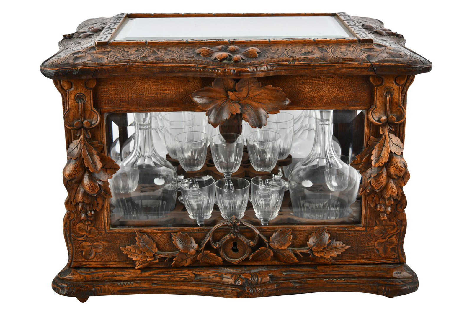 GERMAN CARVED WALNUT TANTALUS: with one missing cordial case: 15 inches wide; 12 inches deep; 11 inches high