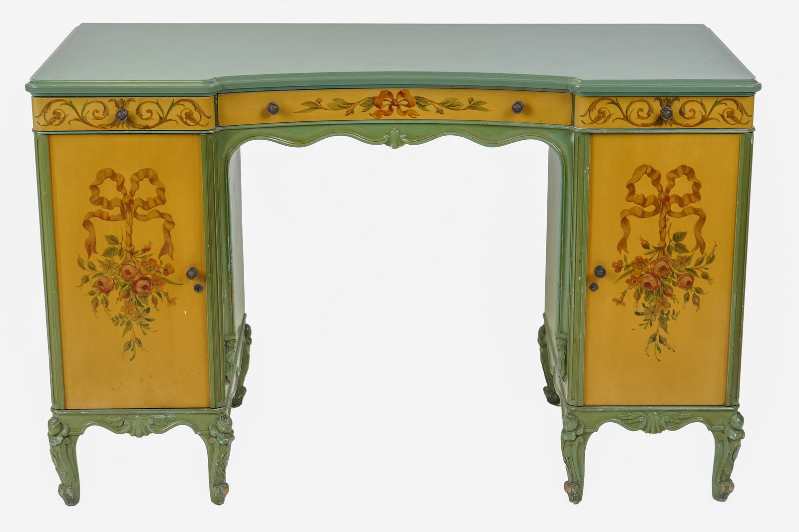 POLYCHROME-PAINTED DRESSING TABLE: green and yellow with neoclassical style floral decorations, having three drawers over a knee hole flanked on either side by a door opening to two interior drawers over a shelf 47 inches wide; 20 1/2
