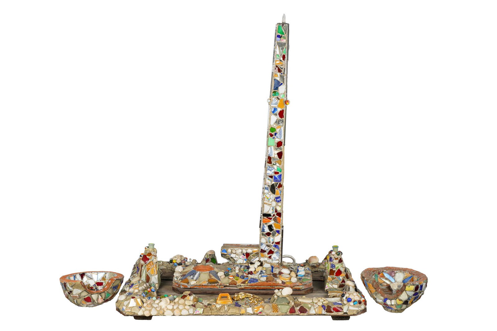 FOUND OBJECT MOSAIC CENTERPIECE: porcelain, shells, glass, wood, rocks, cement and mixed media, comprising an obelisk centerpiece with a removable rectangular block and two basins Provenance: The Estate of Penny Marshall Condition: w