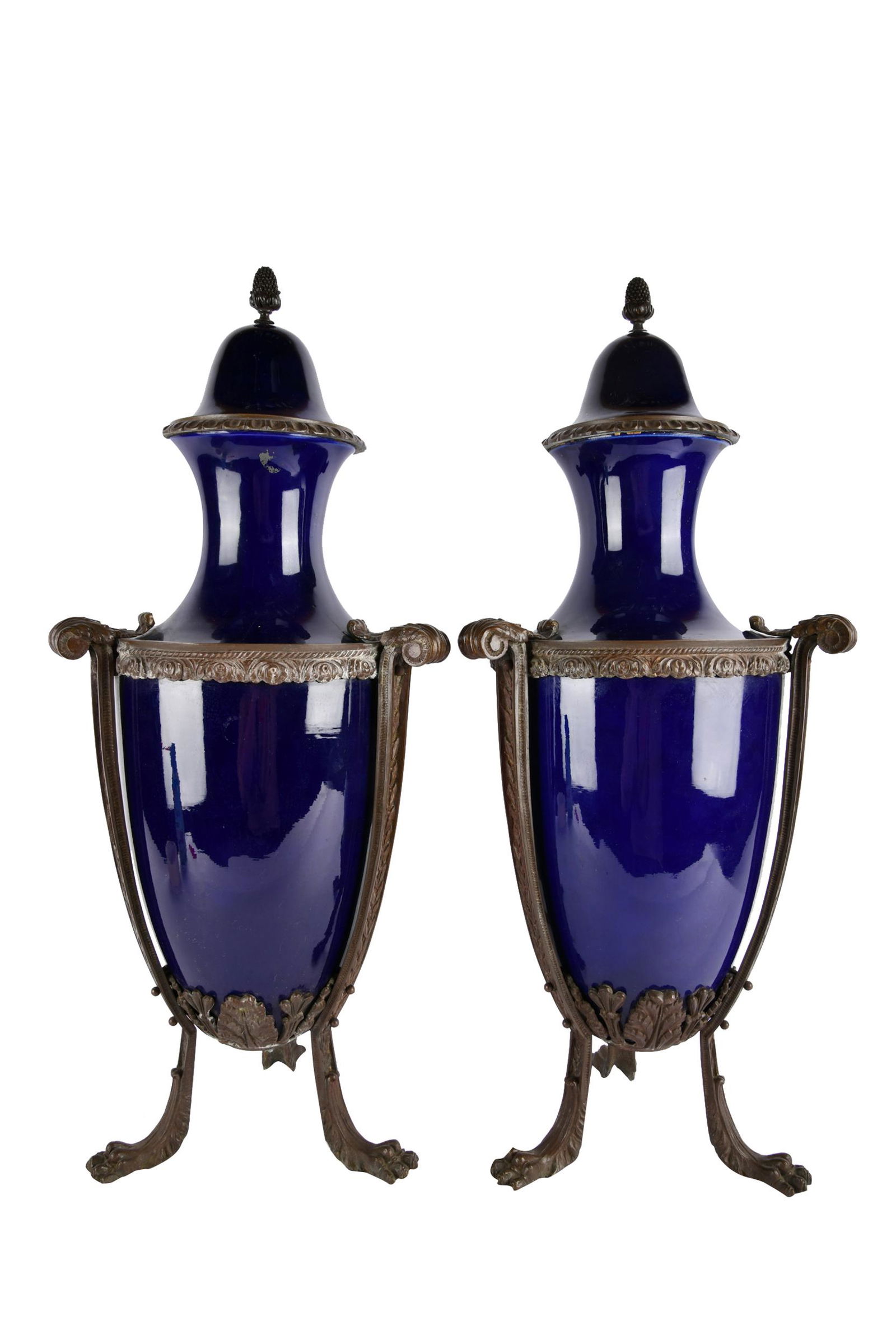 PAIR OF COBALT COVERED URNS: porcelain, each set in bronze base, with removable lids Condition: some scratches and loss to paint 10 1/2 inches diameter; 20 1/2 total inches high