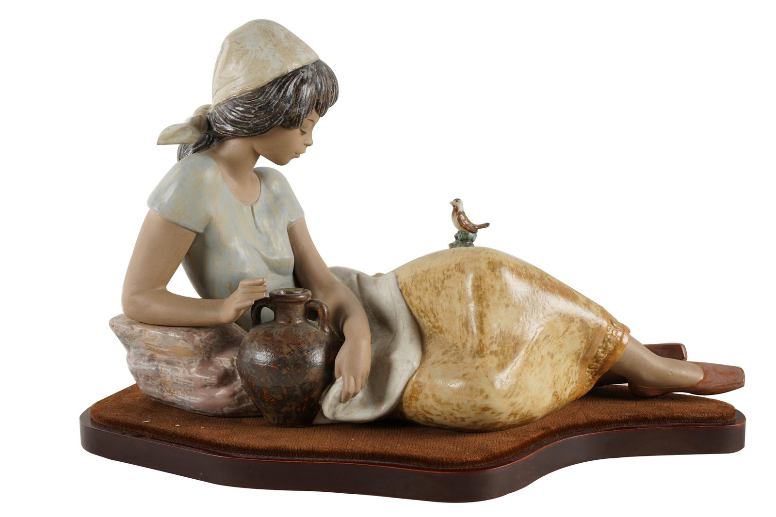 LLADRO PORCELAIN FIGURE OF RECLINING WOMAN: on a fitted wood base; Condition: one finger missing; 17 inches wide; 10 inches high