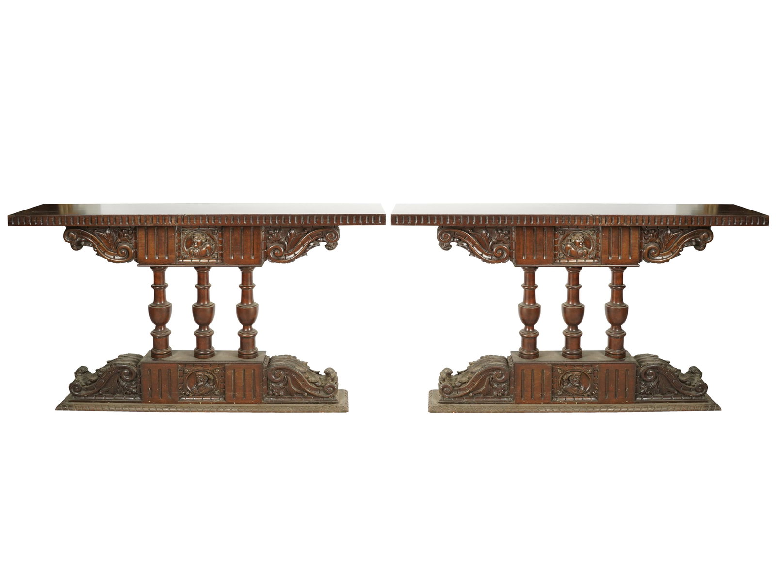 PAIR OF SPANISH REVIVAL CARVED CONSOLES: each with rectangular top raised on three baluster supports; 54 inches wide; 12 inches deep; 30 1/2 inches high