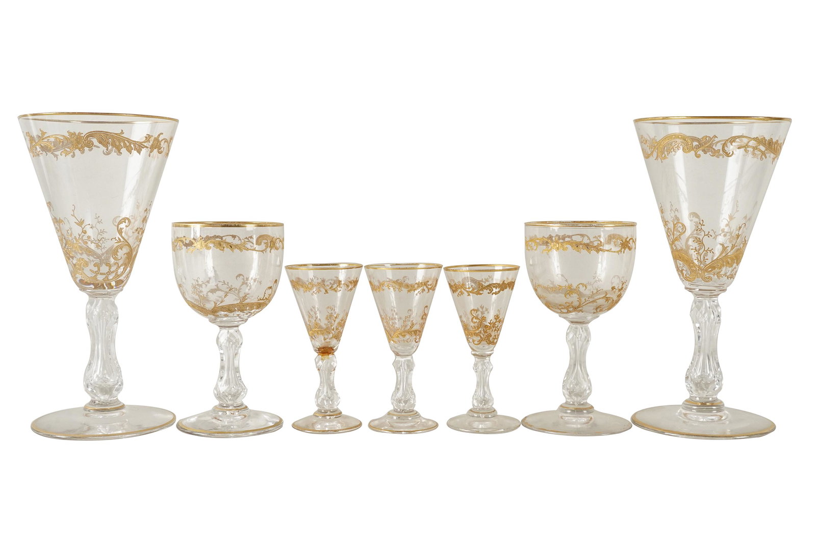 GILT-DECORATED GLASS STEMWARE SERVICE: unmarked; comprising: 9 wine glasses (7" high), 7 port glasses (5" high), and 6 cordials (4" high) [22 pieces]