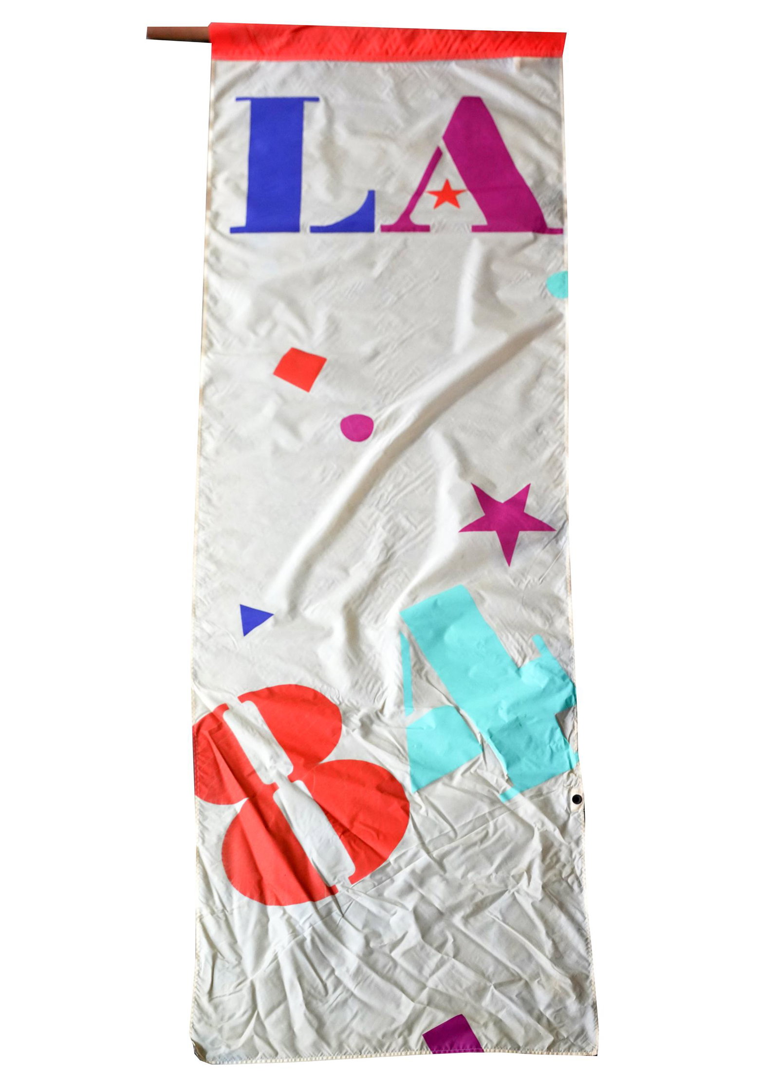 LOS ANGELES 1984 OLYMPIC FLAG: Provenance: The Freund Family Collection; Condition: with discoloration possibly from exposure and areas of black marks; no pole; 9'0" x 3'0"