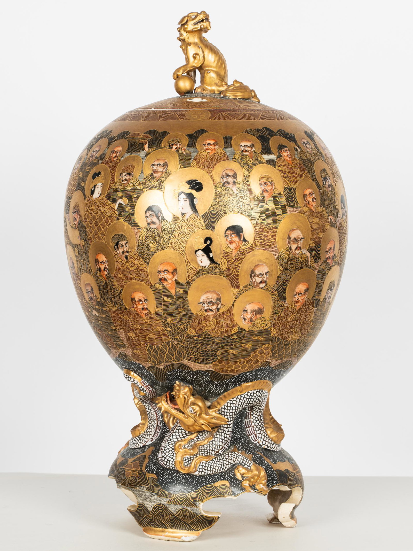 SATSUMA PORCELAIN COVERED CENSER: Meiji Period; marked to underside; the pierced cover with foo dog finial, over an oviform body decorated with immortals, rising from a three-footed base with a molded dragon; Provenance: The Estate of