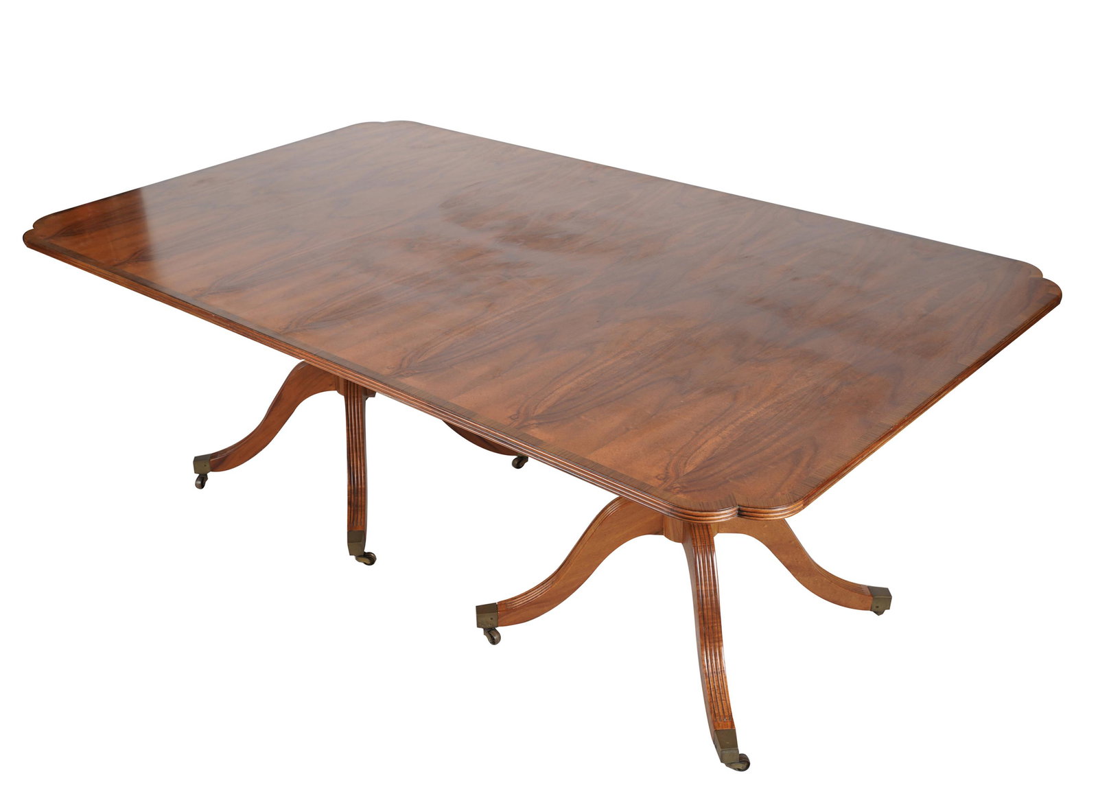 JOHN HALL DESIGNS REGENCY-STYLE DINING TABLE: label to underside; mahogany with cross-banded top, over two quadripartite pedestals raised on casters (no extensions); 80 inches wide; 48 inches deep; 30 inches high