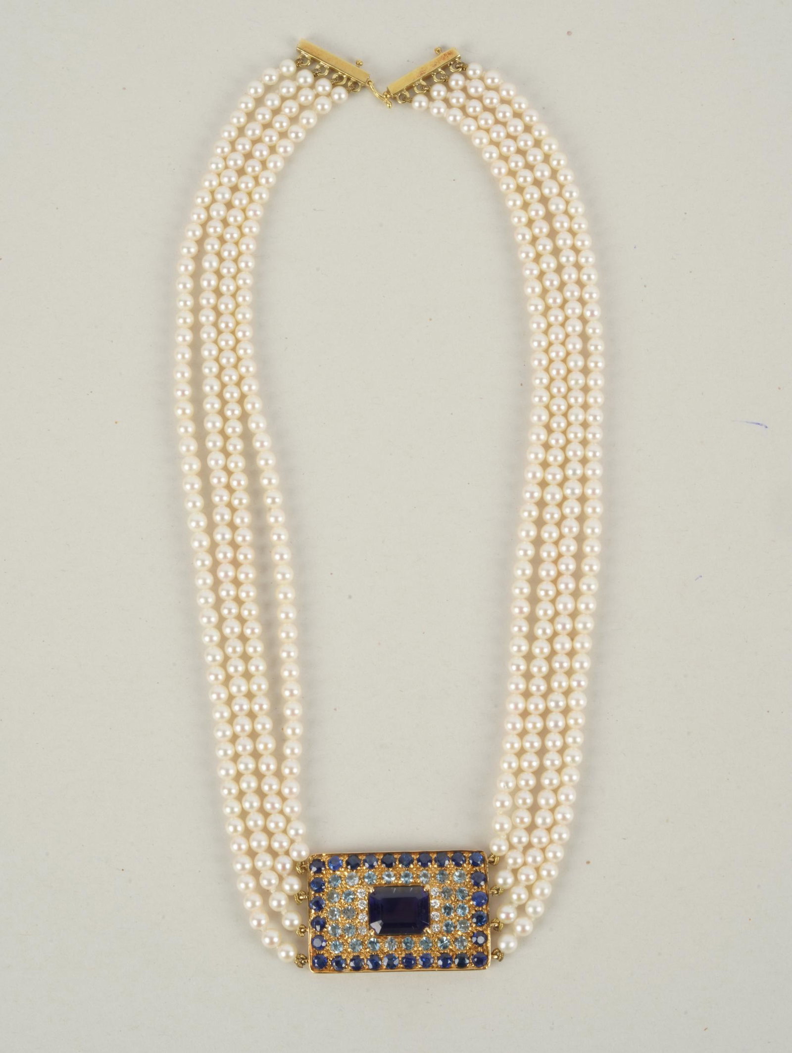 18 KARAT YELLOW GOLD, IOLITE, PEARL, & MUTLI-GEM CHOKER: the pendant centering one rectangular, step-cut iolite weighing approximately 4.25 carat; 28 round aquamarines weighing approximately 1.40 carats total; 28 round sapphires weighing approximately 2.65
