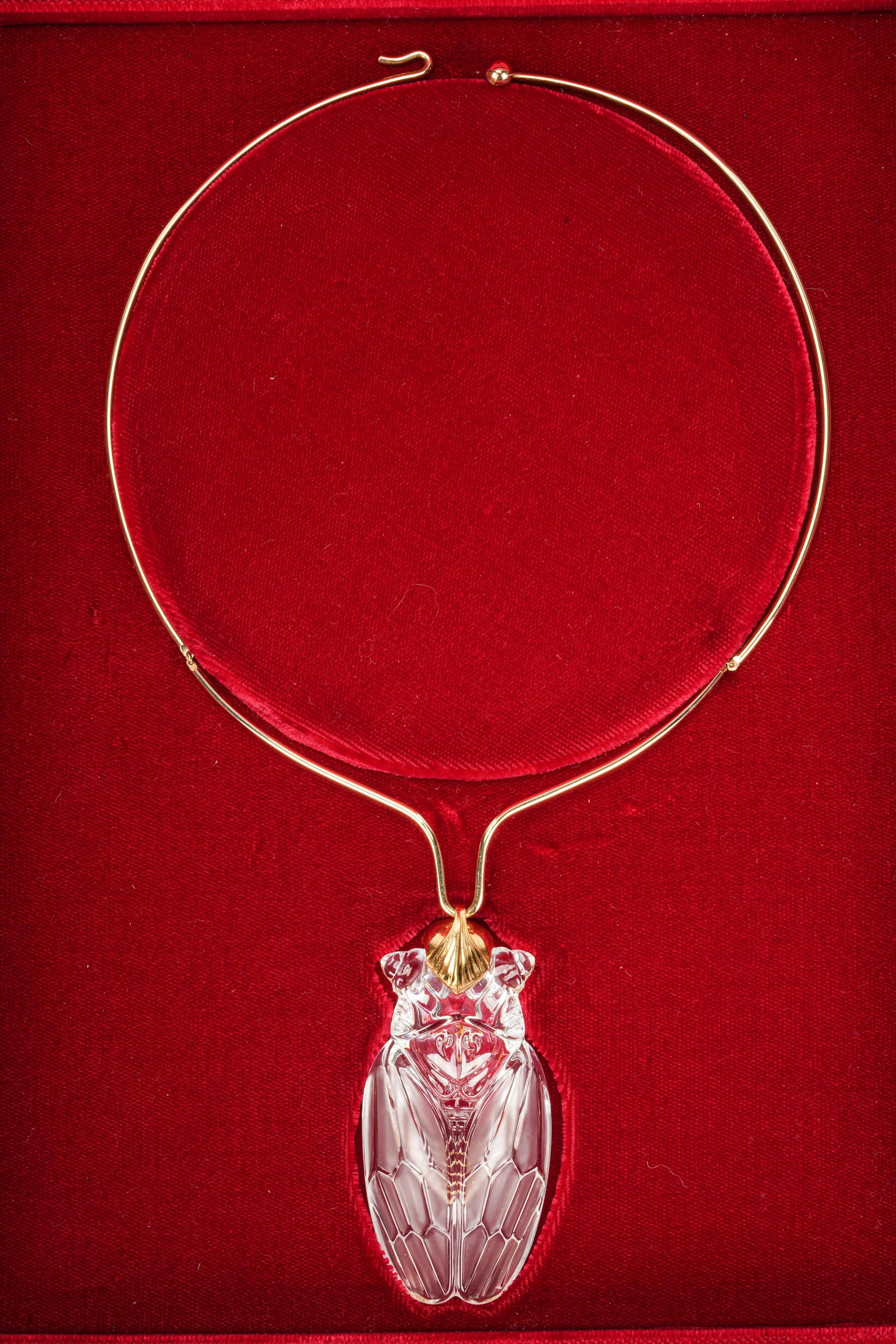 STUEBEN YELLOW GOLD & GLASS NECKLACE: 18 karat yellow gold pendant suspended from a 14 karat yellow gold wire choker (13.7 grams); the pendant depicting a glass cicada measuring approximately 70.15 x 33.10 mm; Note: in original fitted Ste