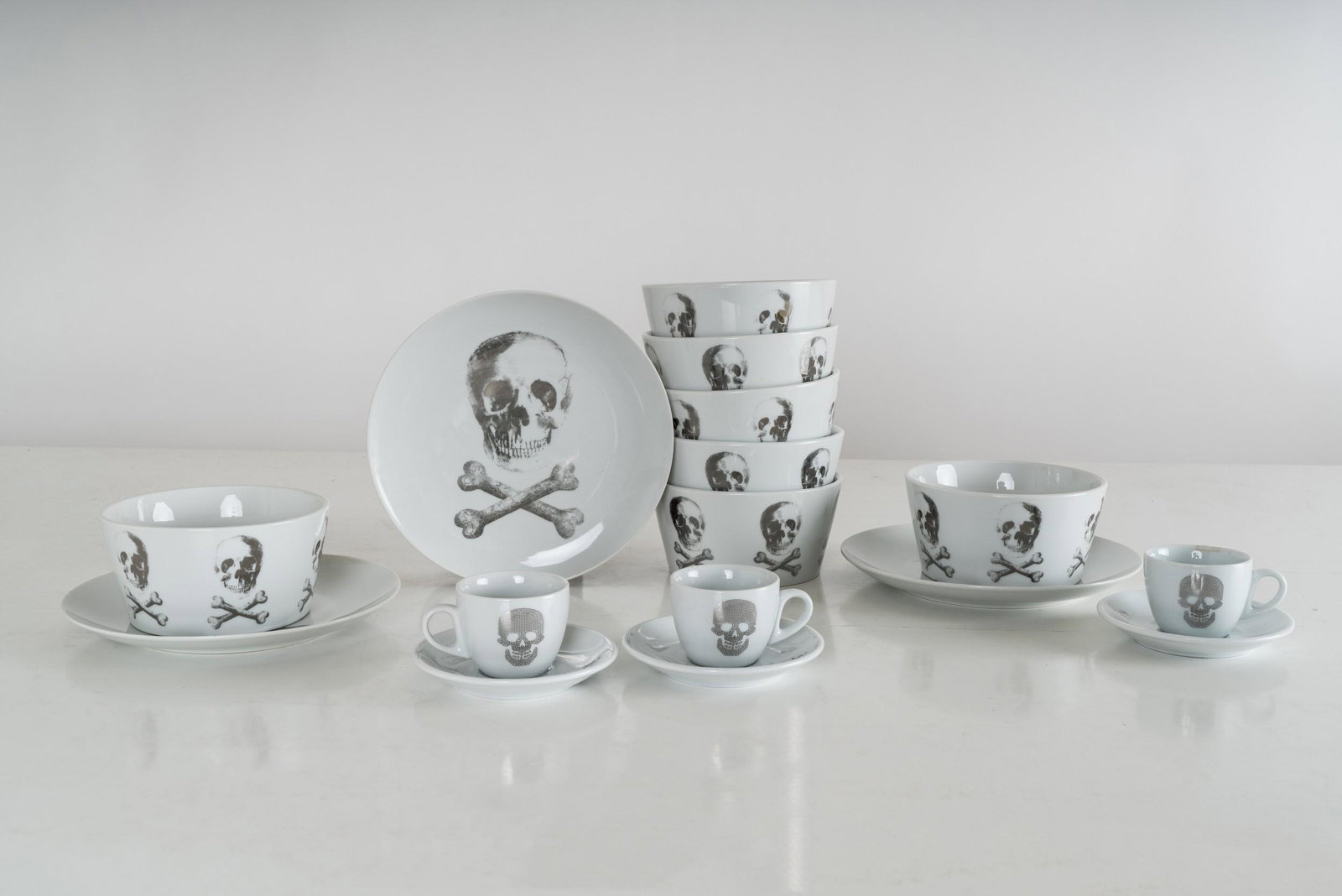 CHRISTIAN AUDIGIER Z GALLERIE SKULL BOWLS AND PLATES: Together with three skull cups and Rio de Janerio Brasil saucers; Together with three skull cups and Rio de Janerio Brasil saucers. Comprising three plates (8 1/4 inches diameter), eight bowls (5 1/2 