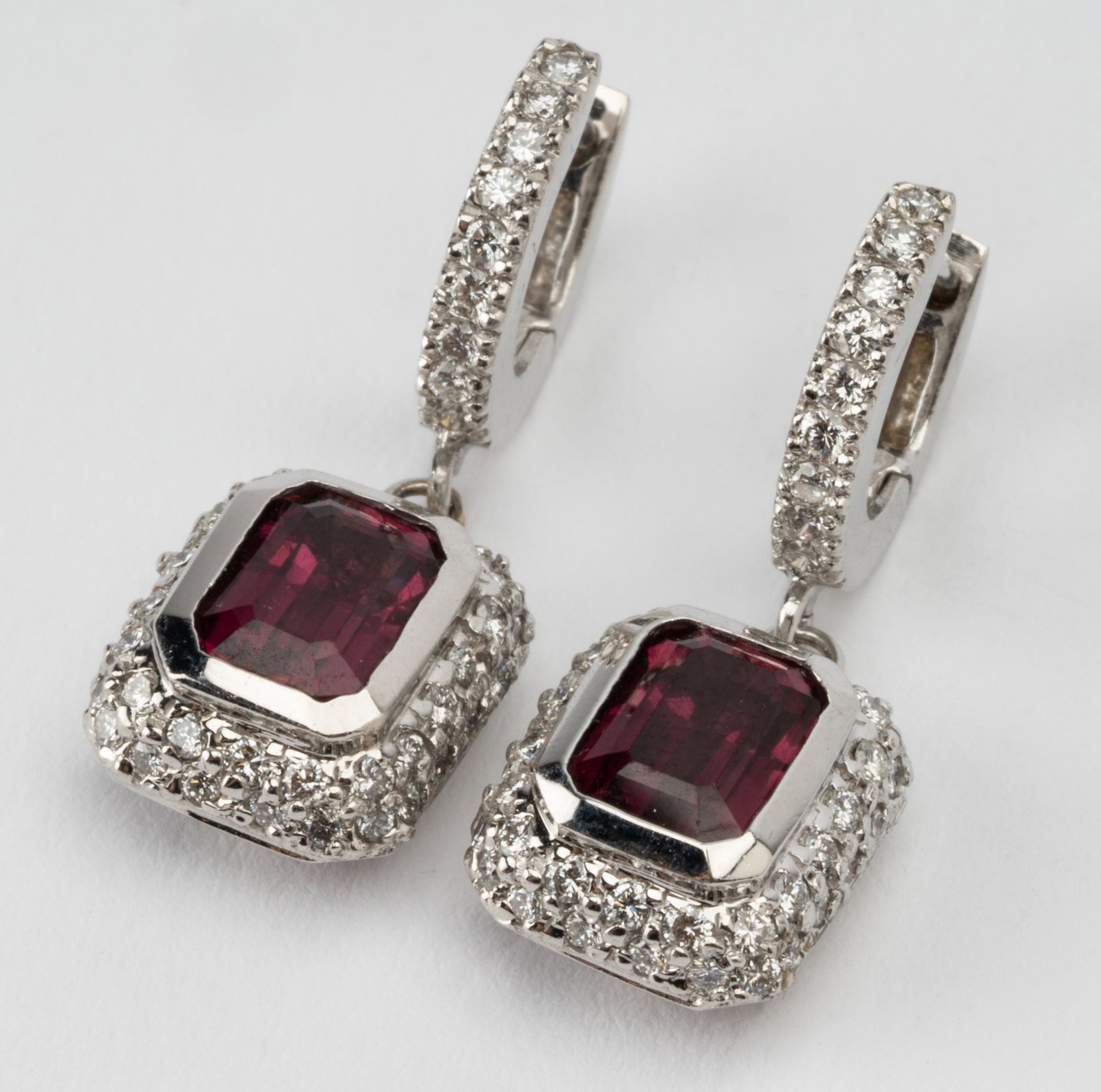 PAIR OF 18 KARAT WHITE GOLD, DIAMOND, & TOURMALINE EARRINGS: containing two rectangular, cut-corner, step-cut rubellite tourmalines weighing approximately 1.60 carats total; and 86 full-cut diamonds [H-I/VS] weighing approximately 0.50 carats total; 7.5 grams; 