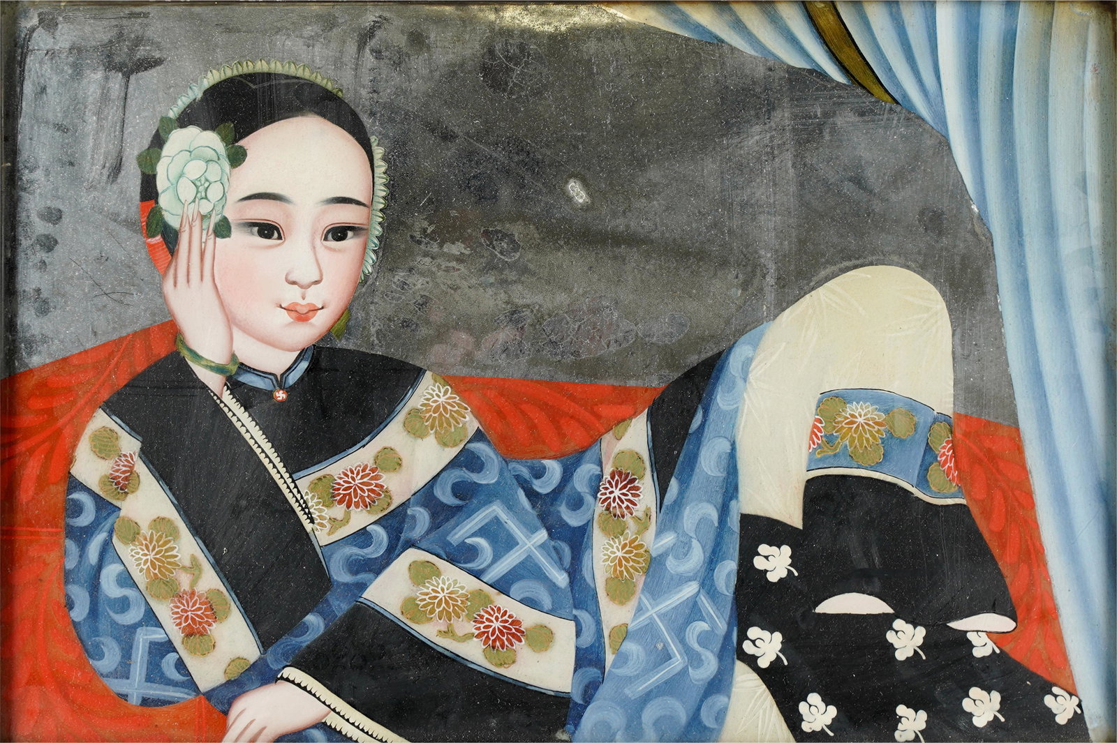 A REVERSE GLASS MIRROR PAINTING OF A COURT LADY IN BLUE ROBE: 19TH Century; the silver surface painting with a blue curtain opening to reveal an elegantly attired court lady reclining on a daybed, her blue robe encircled by chrysanthemum borders; Condition: no a