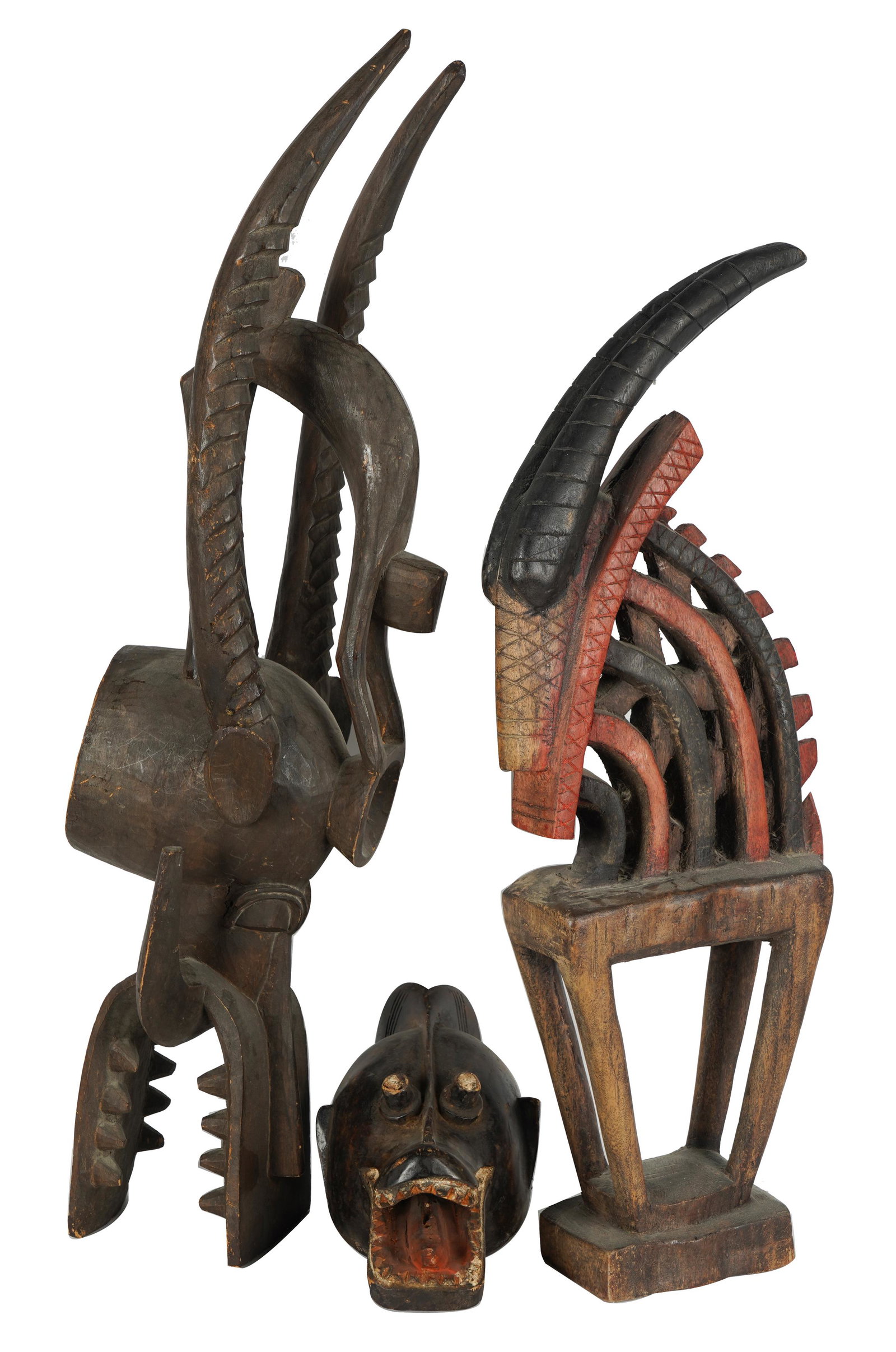 THREE AFRICAN-PAINTED WOOD CARVINGS: comprising a mask (7 inches wide; 6 1/2 inches deep; 12 1/2 inches high); figure with horns (34 1/2 inches high); and an animal carving (10 1/2 inches wide; 28 3/4 inches high); Condition: the horned 