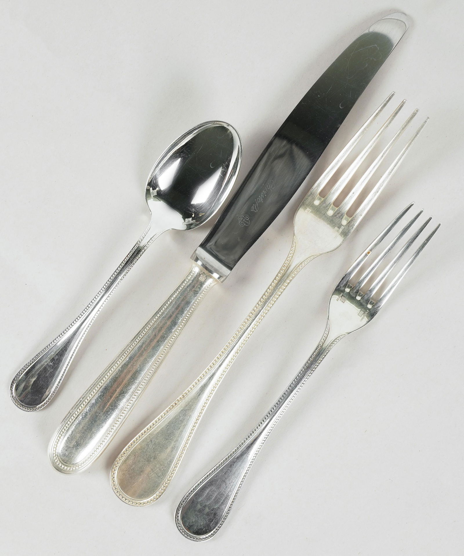 Christofle Silverplate Assembled Partial Flatware Service: comprising 6 silver-plate dinner forks (8 1/8 in.), 6 silver-plate dessert forks (6 3/4 in.), 5 stainless steel teaspoons (5 7/8 in.), 2 silver-plate five o'clock teaspoons (5 3/8 in.), and 6 steel-bl