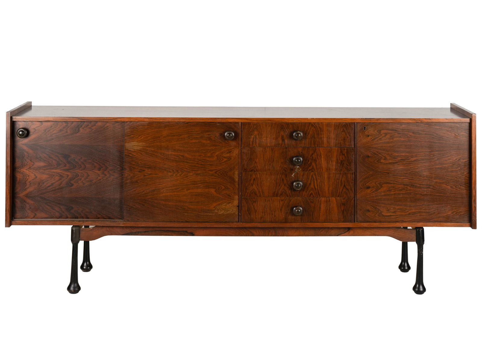 Italian Mid-Century Modern Rosewood Sideboard: unsigned; having three hinged doors and four drawers; with key 34 1/2 x 88 x 17 3/4 in. (87.6 x 223.5 x 45.1 cm.)