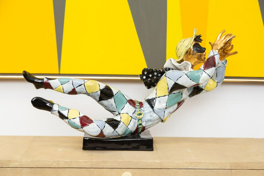 Vintage Italian Ceramic Harlequin Figure: probably Otello Rosa for San Polo, Venezia; unsigned; polychrome-glazed, with gilt face and hands, bolted to black ceramic plinth 12 x 22 x 9 1/2 in. (30.5 x 55.9 x 24.1 cm.) Property from the persona