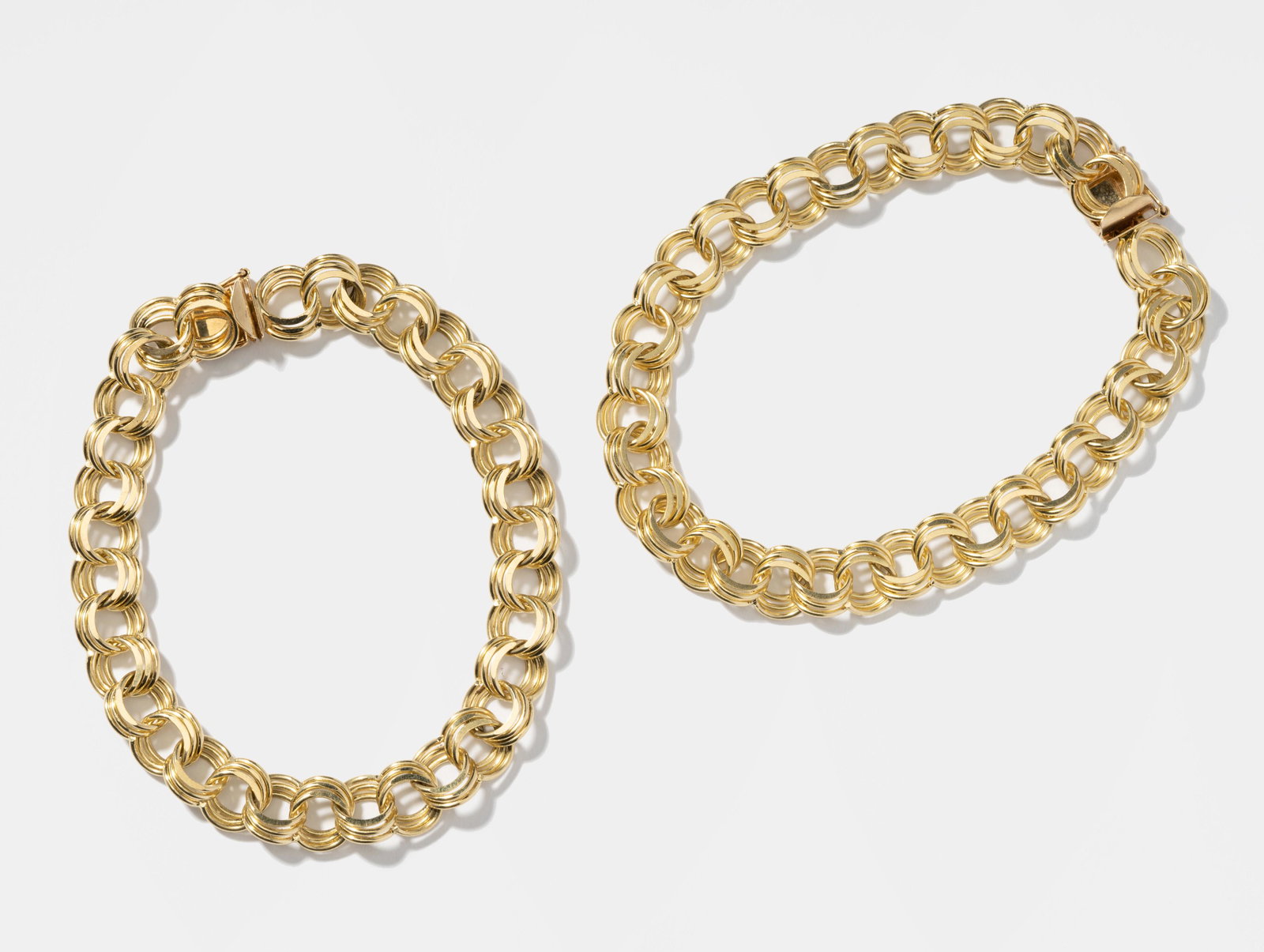 Two 14 Karat Yellow Gold Circular Link Bracelets: Including a 14 Kt. yellow gold triple link bracelet completed with concealed box clasp with figure 8 lock, 20.2 grams, measuring 7-3/4 inches long by 9.48 mm. wide, 20.1 grams, and a matching 14 Kt. y