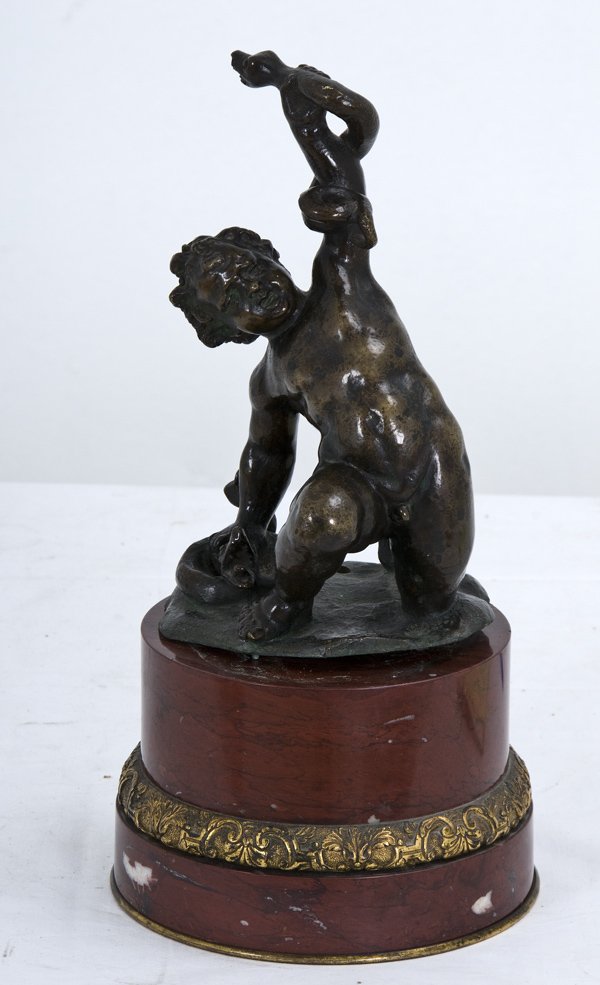 THE INFANT HERCULES: after Francesco Fanelli bronze figure with brown patina, on a rouge marble pedestal Condition: the bronze and the base having been drilled for a lamp the figure measuring 9 1/4 inches high