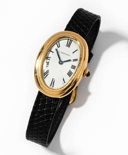 Cartier 18 Karat Yellow Gold Baignoire Quartz Watch: Cartier "Baignoire" quartz movement wristwatch with oval double gold bezel surrounding a 24.00 x 16.00 mm. in diameter white dial with blued steel index shape hour and minute hands, black enamel Roman