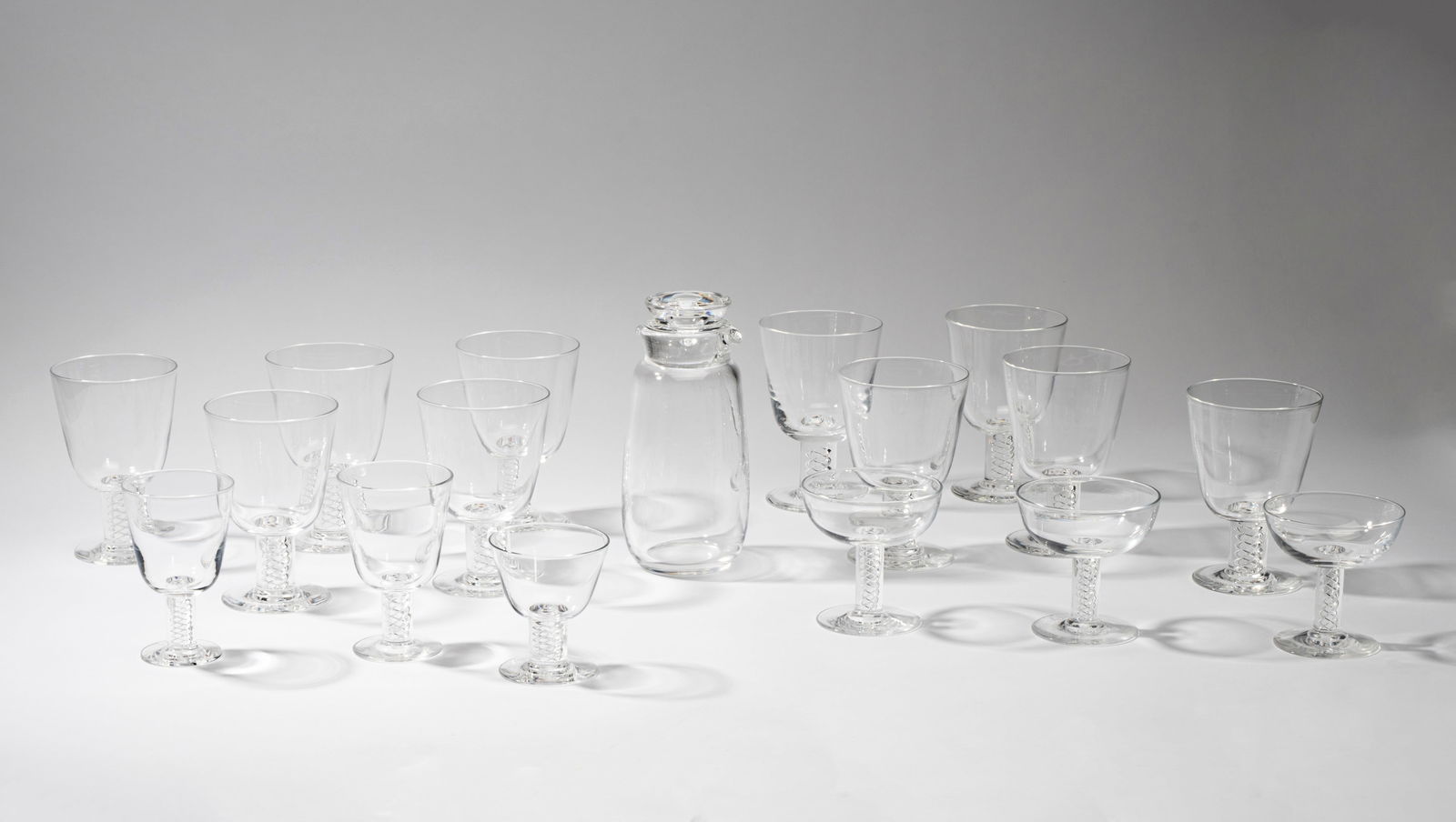 Steuben Glass Drinks Service: comprising 10 water goblets (5 3/4 in. high), 2 wine glasses (4 3/4 in. high), 3 champagne coupes (4 in. high), 1 cocktail glass ( 3 7/8 in. high), and a carafe (8 1/4 in. high); each piece signed [17