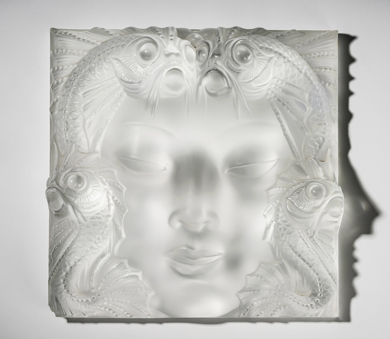Lalique Molded Glass Relief Plaque: "Masque De Femme"; unsigned 12 1/2 x 12 1/2 x 3 in. (31.8 x 31.8 x 7.6 cm.) Provenance: From the Pacific Palisades estate and collection of Mr. and Mrs. Hoyt S. Pardee, the founder of Pardee Construct