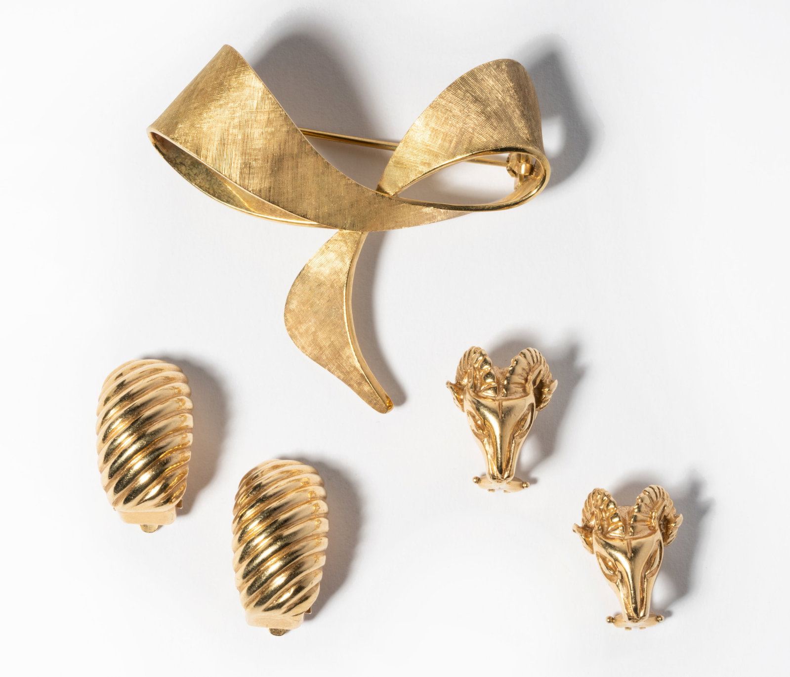 Group of 14 Karat Yellow Gold Jewelry: Including a gold free-form bow motif brooch with Florentine finish, 6.0 grams, 48.00 x 44.00 mm. in diameter; gold ram motif earrings with clip backs for non-pierced ears, 8.1 grams, 16.00 x 11.00 mm.