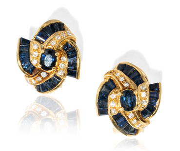 Pair of 18 Karat Yellow Gold, Diamond, and Sapphire Earrings: earrings with convertible post/Omega clip backs, featuring two oval mixed cut Blue Sapphires, approximate total weight 0.28 carats, accented with 36 tapered baguette cut Blue Sapphires, approximate to