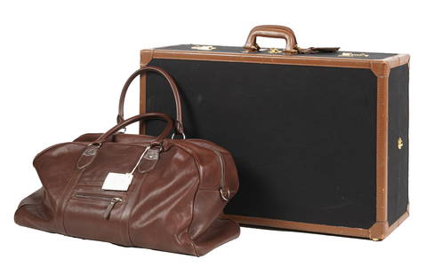 Two Pieces of Designer Luggage: the first: a Brunello Cucinelli leather weekend bag, 12 x 23 x 9 in. (30.5 x 58.4 x 22.9 cm.); the second: a T. Anthony hardside suitcase in black fabric with tan leather trim 11 x 27 3/4 x 18 1/4