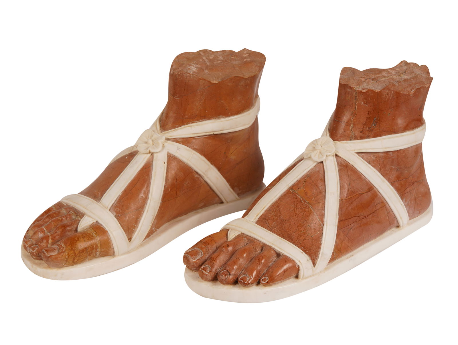 Pair of Italian Carved Stone Feet: modern; depicted in ancient Roman-style sandals; unsigned Each: 8 x 15 x 5 1/2 in. (20.3 x 38.1 x 14 cm.)
