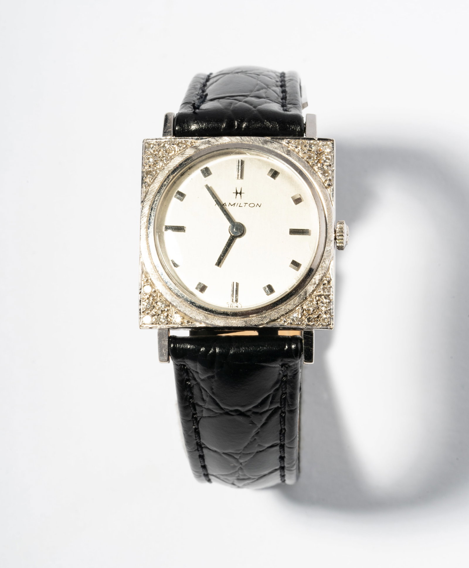 Hamilton 14 Karat White Gold Diamond Watch: mechanical movement, with silver dial measuring 21.5mm in diameter and case measuring 25.6mm wide set with 24 round diamonds [M/SI] approximately .12 carats, leather band measuring 8-1/2 inches long;