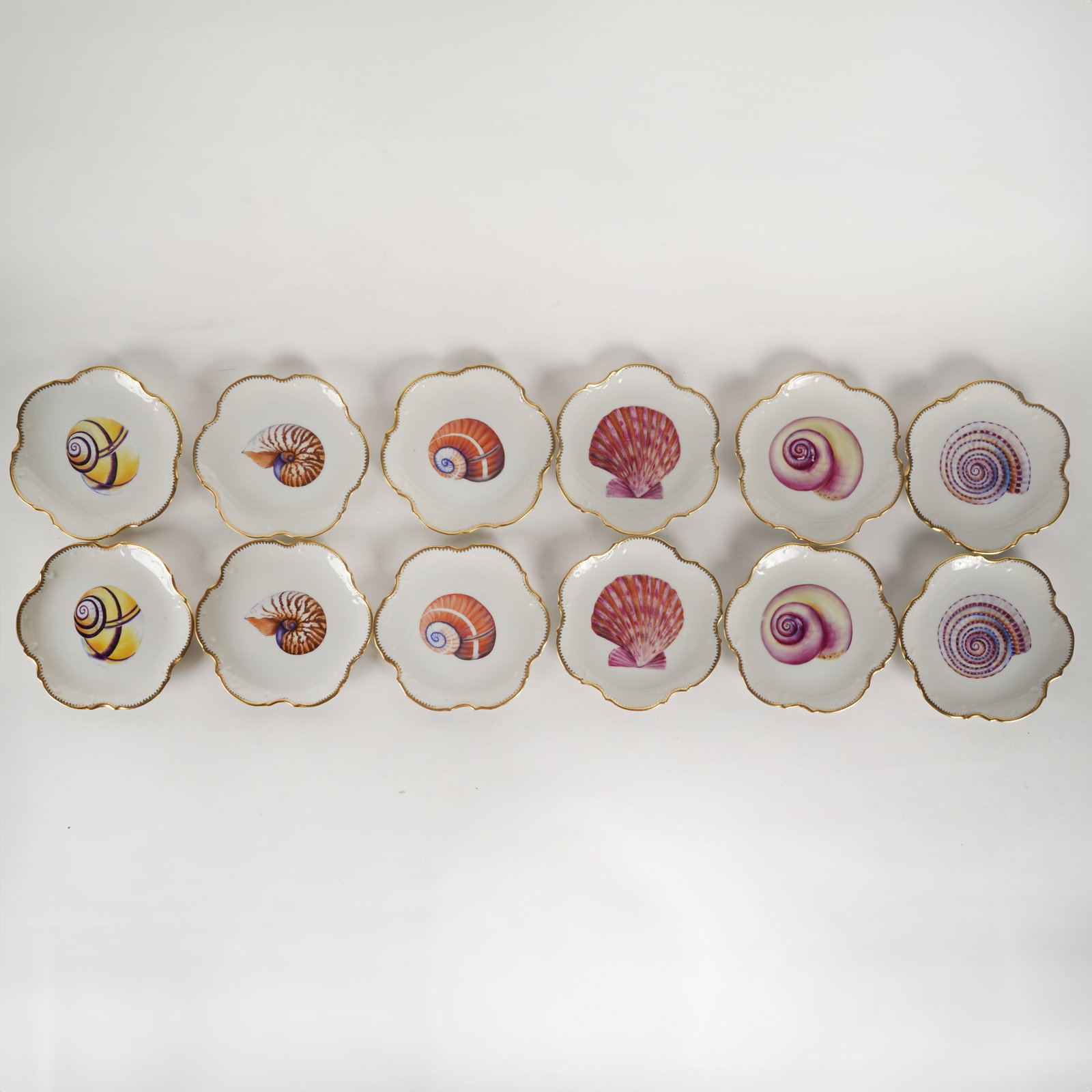 Set of 12 Anna Weatherley Porcelain Shell Plates: Hungary, late 20th/21st century; each marked Each 6 1/2 in. 16.5 cm.) dia. Provenance: Property from a Southern California Estate