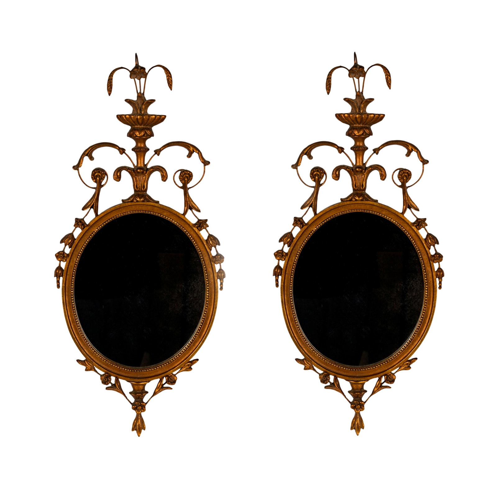 Pair of Neoclassical-Style Oval Wall Mirrors: each giltwood frame surrounding a flat mirror plate 28 x 12 1/2 in. (71.1 x 31.8 cm.) Provenance: Estate property from a Palos Verdes, CA Chateau