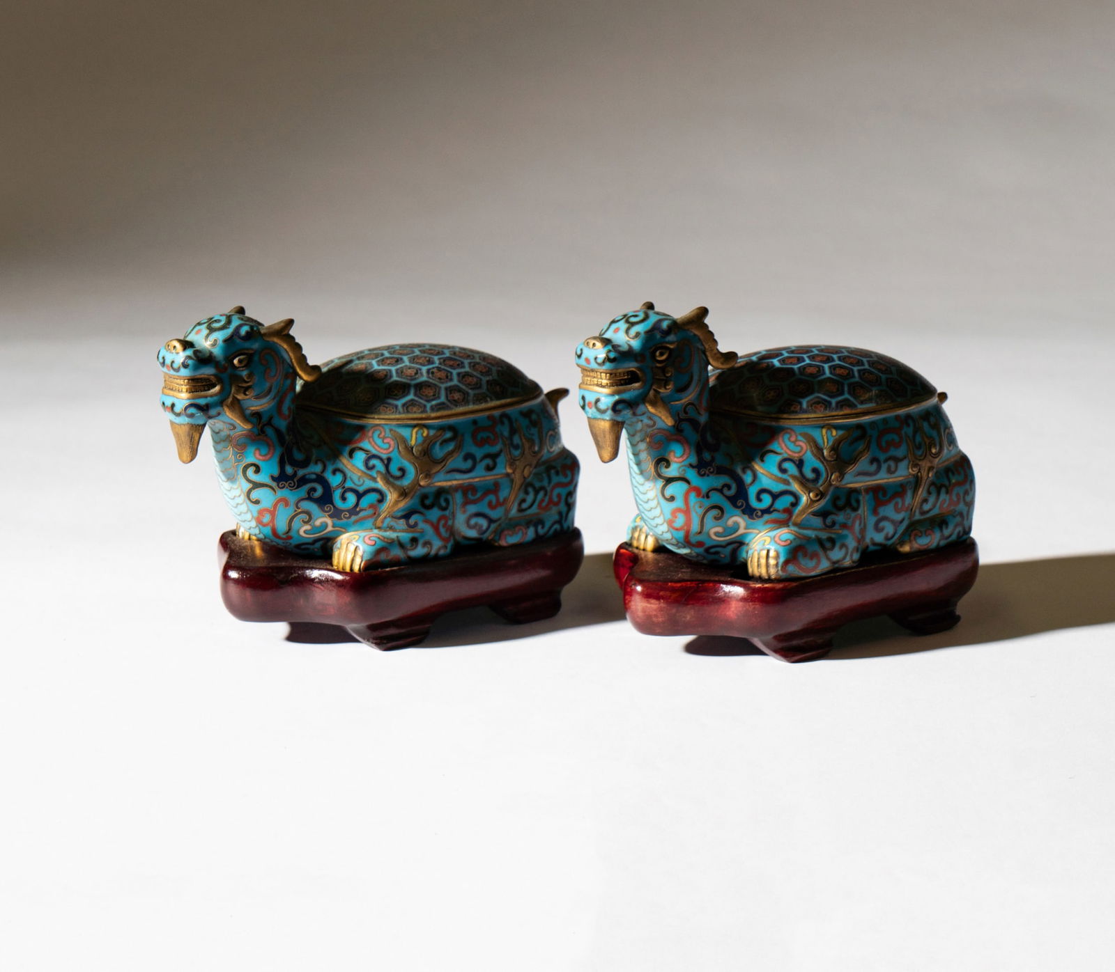 A Pair of Chinese Cloisonne Dragon Censers: each with wooden stand; unmarked Each excluding stand: 3 1/2 x 6 1/4 x 3 1/2 in. (8.9 x 15.9 x 8.9 cm.) Provenance: Property from a Beverly Hills, CA Estate