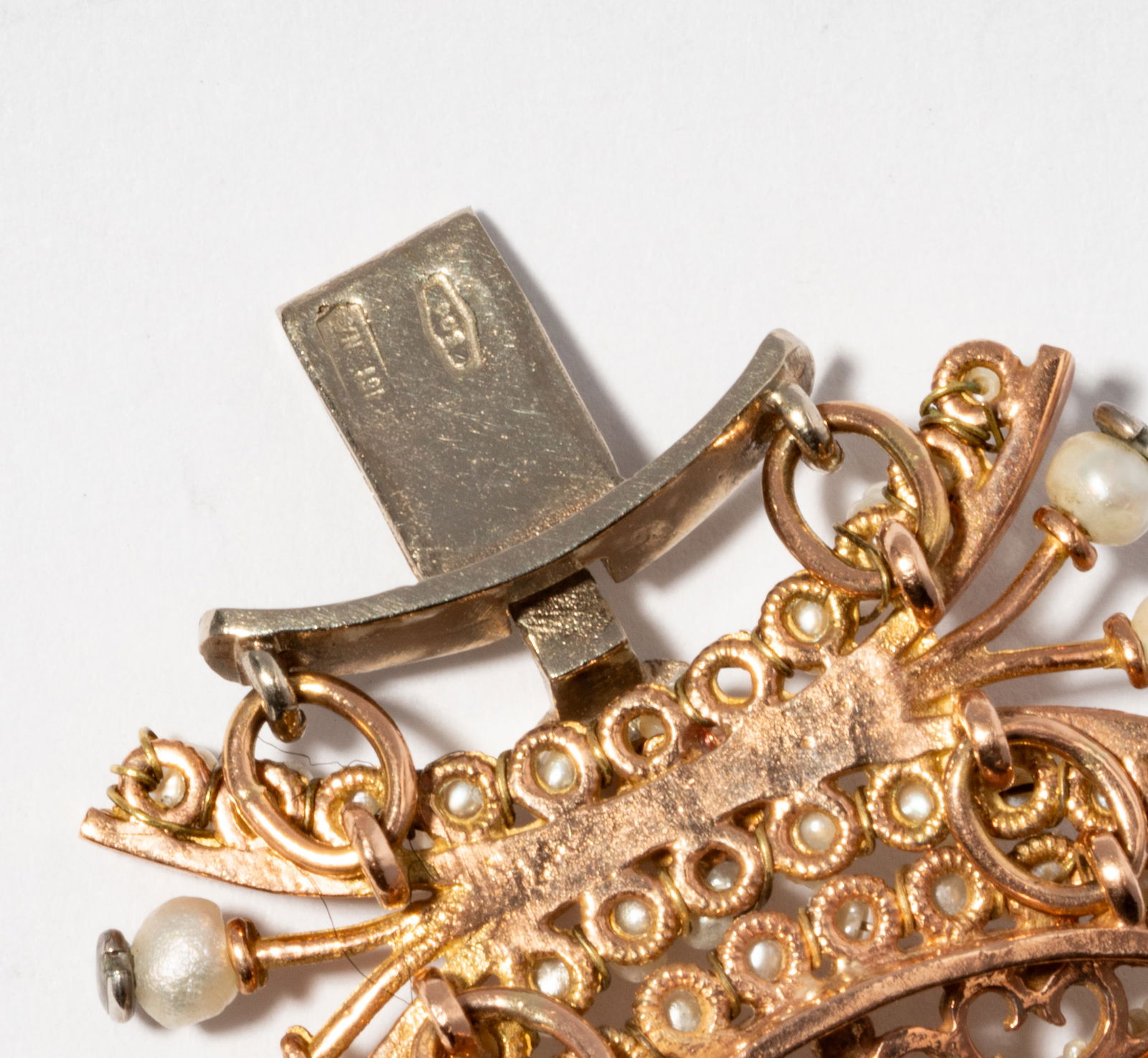 12 Karat Pink Gold, Emerald and Pearl Bracelet: bracelet set with numerous 1.30 - 2.50 mm. in diameter Pearls, accented with 24 round cut Emeralds, approximate total weight 0.84 ct., 42.8 grams, 6-12" long by 29.00 mm. wide, completed with a concea