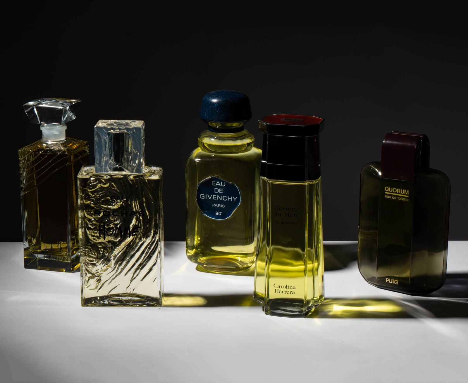 A Group Of Oversized Factice / Dummy Perfume Display Bottles: comprising "Eau de Givenchy" (15 in. high), Guerlain "Jardins de Bagatelle" (13 3/4 in. high), "Herrera for Men" (14 1/2 in. high), Puig "Quorum" (12 1/2 in. high), and "Eau de Richas pour Homme" (14