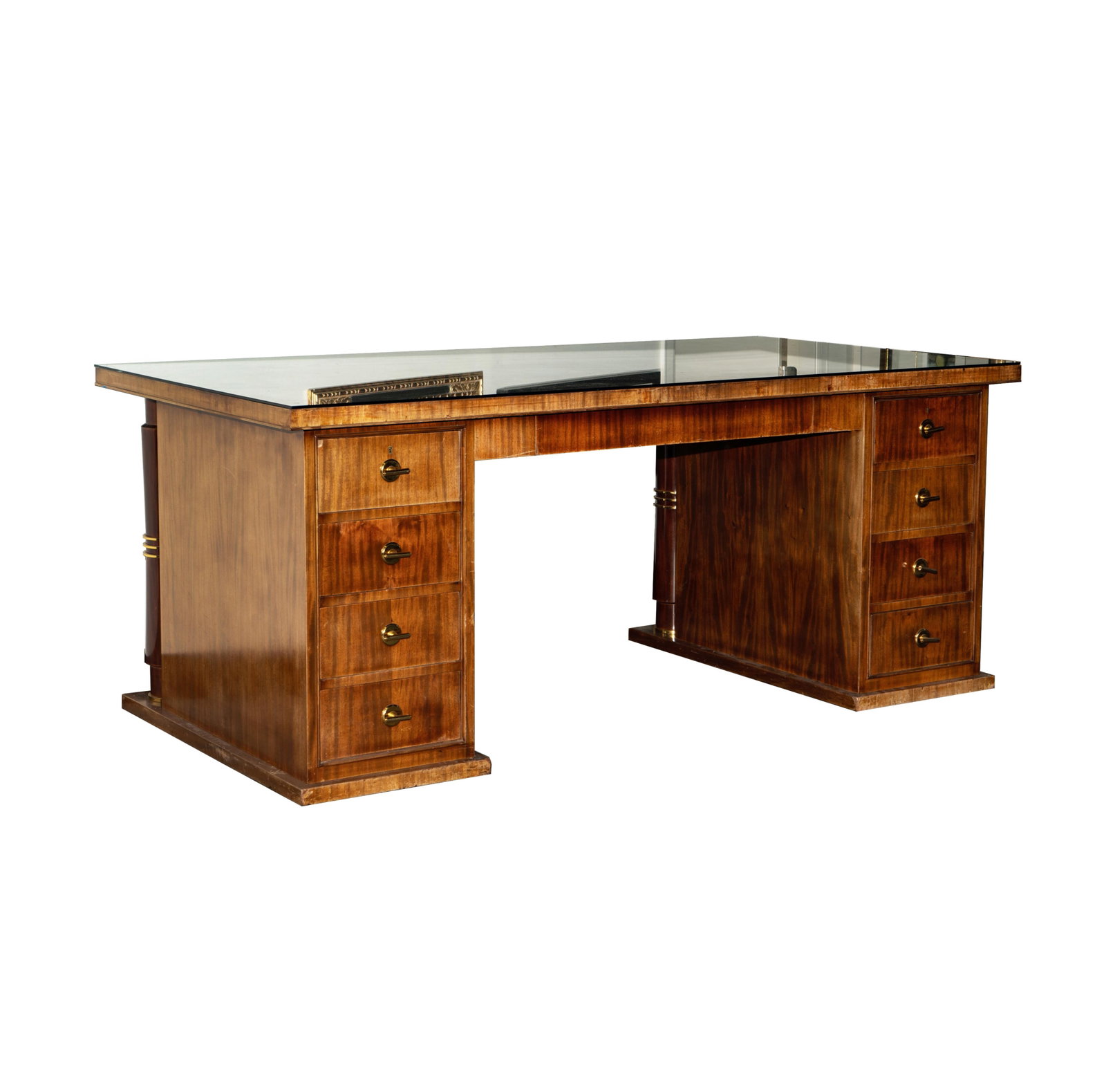 An Art Deco Brass-Mounted Mahogany Desk: c. 1940; the rectangular top over a central drawer flanked by two banks of four drawers each, the opposite side with two pairs of disengaged columnar supports; with removable glass cover and two keys;
