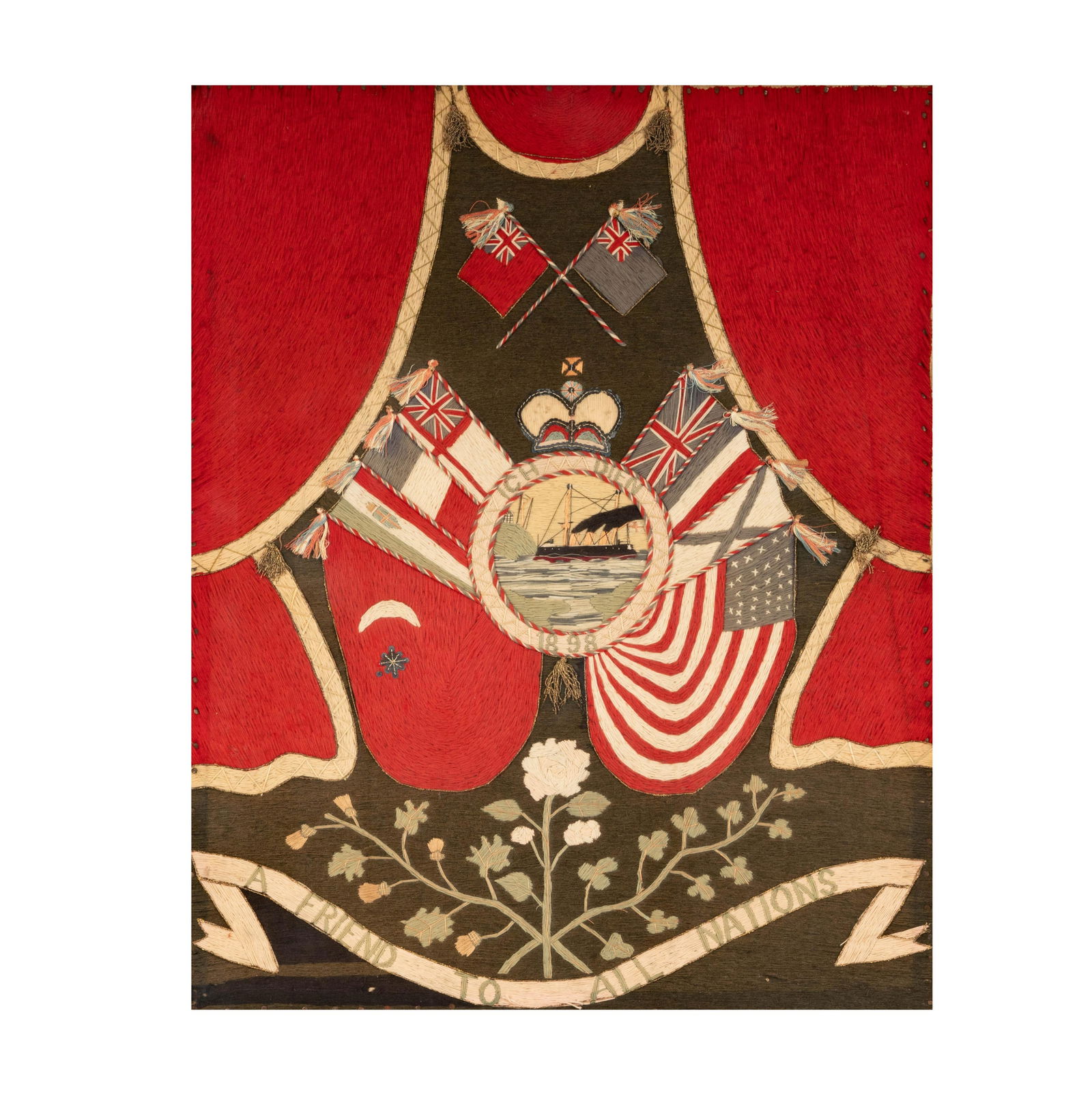 An English Wool Work Picture (Woolie): Steam Vessel Vignette: late 19th century; the central vignette with motto "Ich Dien" and dated "1898", surmounted by a Crown and surrounded by flags of Britain and other nations, over a banner inscribed "A Friend To All Nat