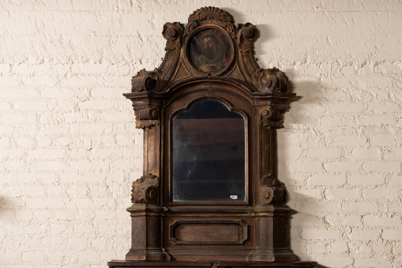 A Spanish Baroque Gilt and Faux Marble-Painted Altar Frame: the crest inset with a painted canvas panel depicting a saint, over a later-added mirror plate 57 x 38 x 8 in. (144.8 x 96.5 x 20.3 cm.) Provenance: Property from the Estate of Francis and Marion Lede