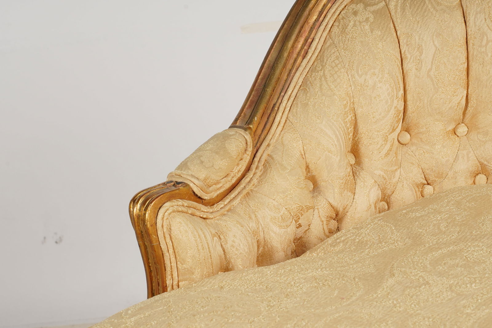 A Louis XV-Style Giltwood Chaise Longue: the frame with black-painted accents, covered with gold-colored damask fabric 31 x 61 x 28 in. (78.7 x 154.9 x 71.1 cm.)