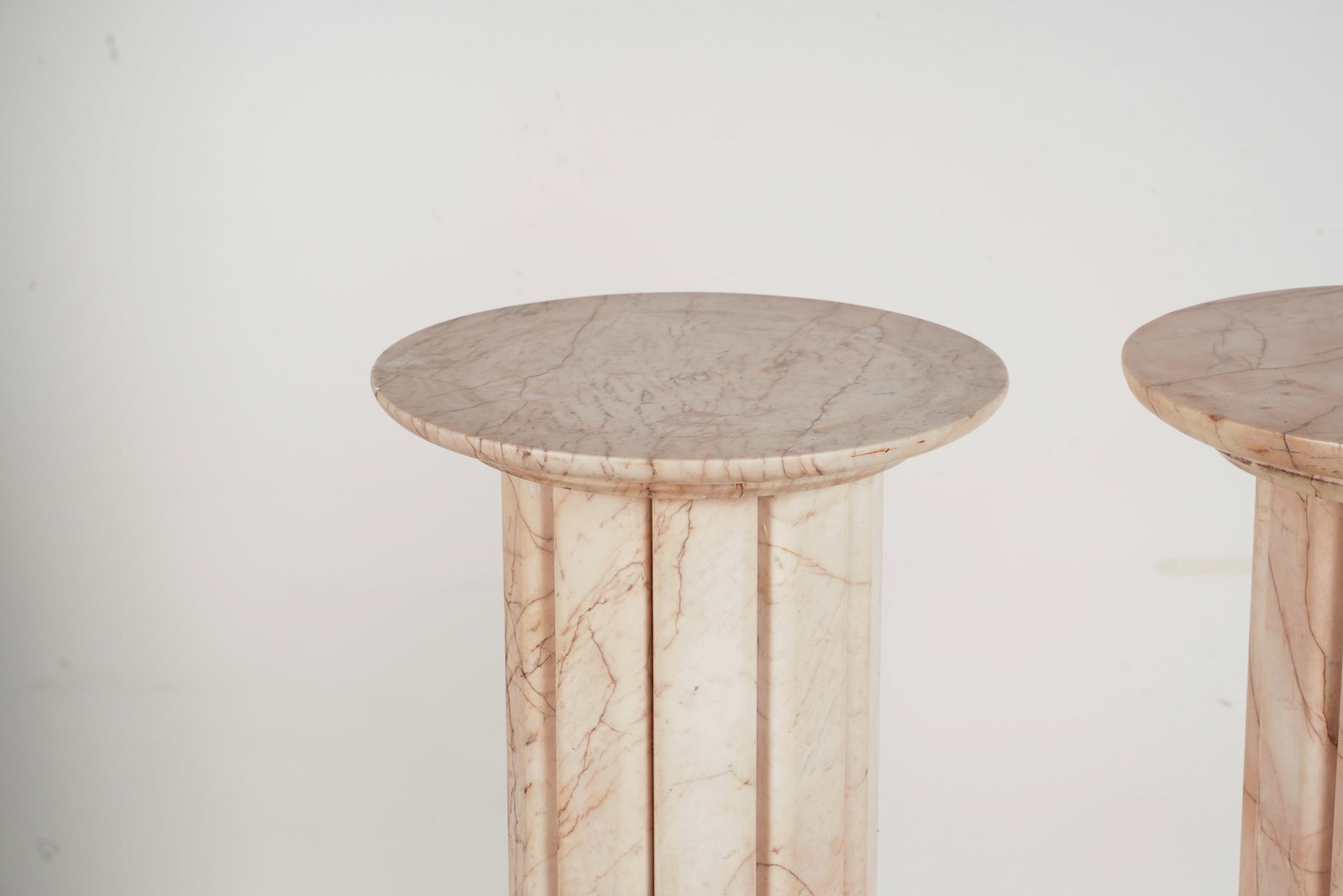 A Pair of Art Moderne-Style Pink-Veined Marble Pedestals: each with round platform on reeded column and stepped round base 38 3/4 x 13 in. (98.4 x 33 cm.)