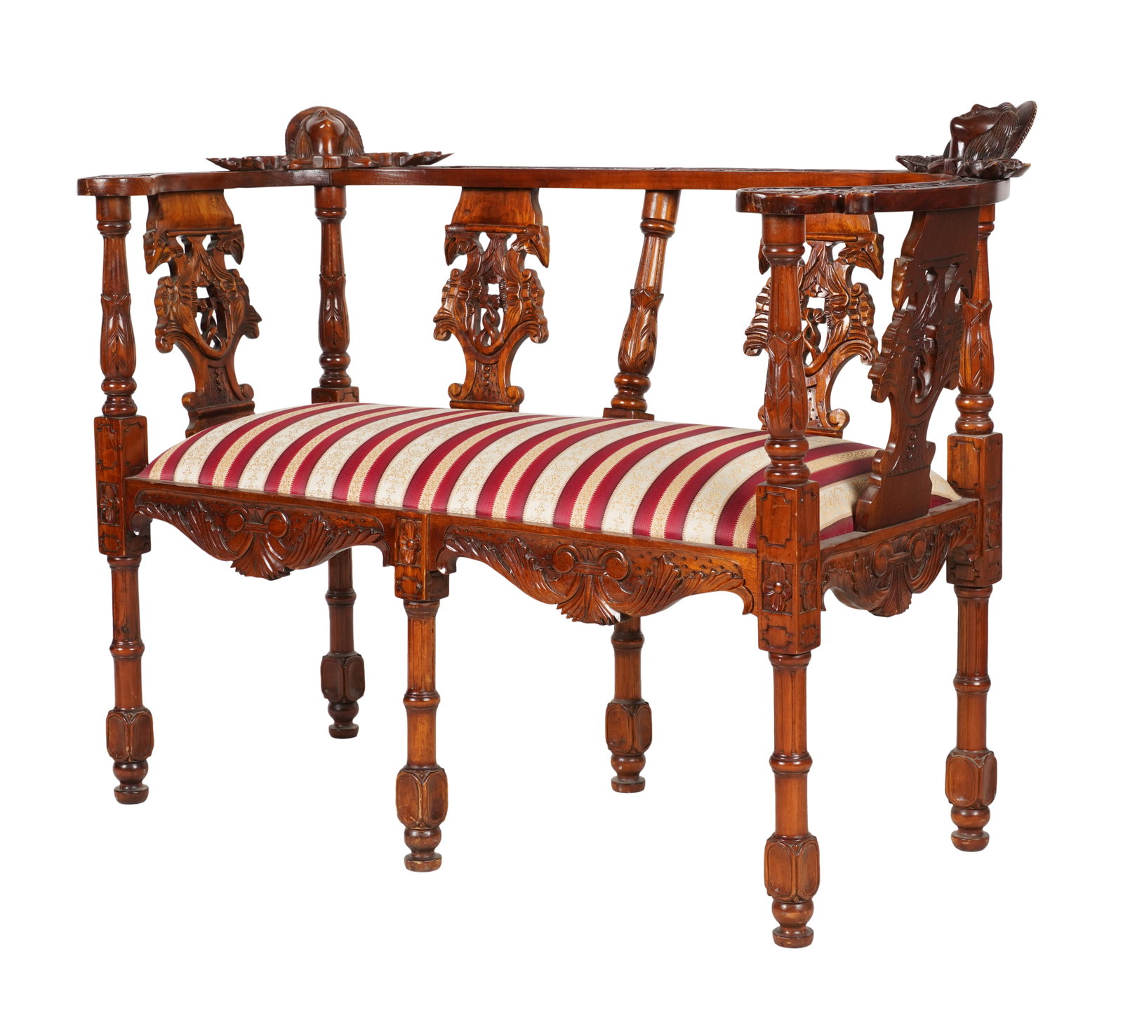A Carved Mahogany Bench: the curved crest rail surmounted by two male heads 35 1/2 x 48 x 22 1/2 in. (90.2 x 121.9 x 57.2 cm.), Seat height: 19 in. (48.3 cm.)