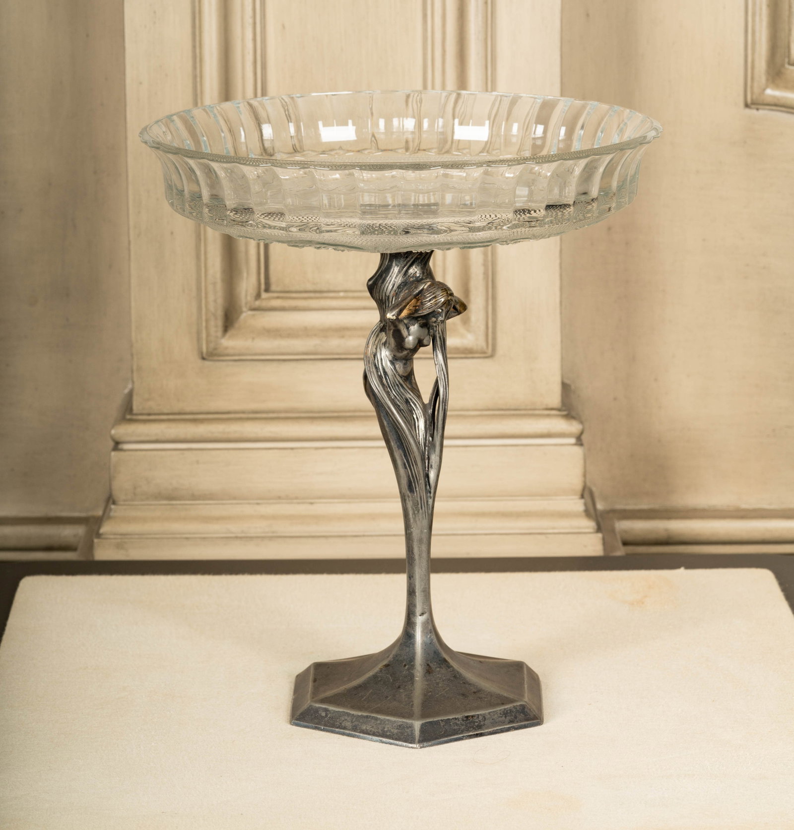 Nouveau-Style Silverplate and Molded Glass Compote: silverplated nude figure with mounted molded glass top 13 1/2 x 11 3/4 in. (34.3 x 29.8 cm.)