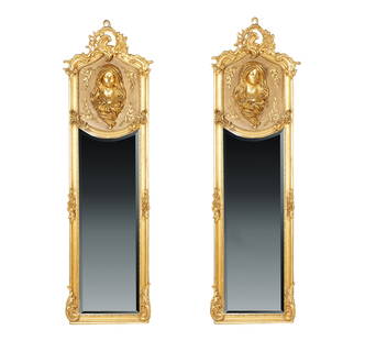 A Pair of Giltwood Wall Mirrors: contemporary; each relief-carved with a bust of a maiden 70 1/2 x 20 3/4 in. (179.1 x 52.7 cm.) This item does not qualify for in-house shipping. Please refer to our preferred shipper's list at