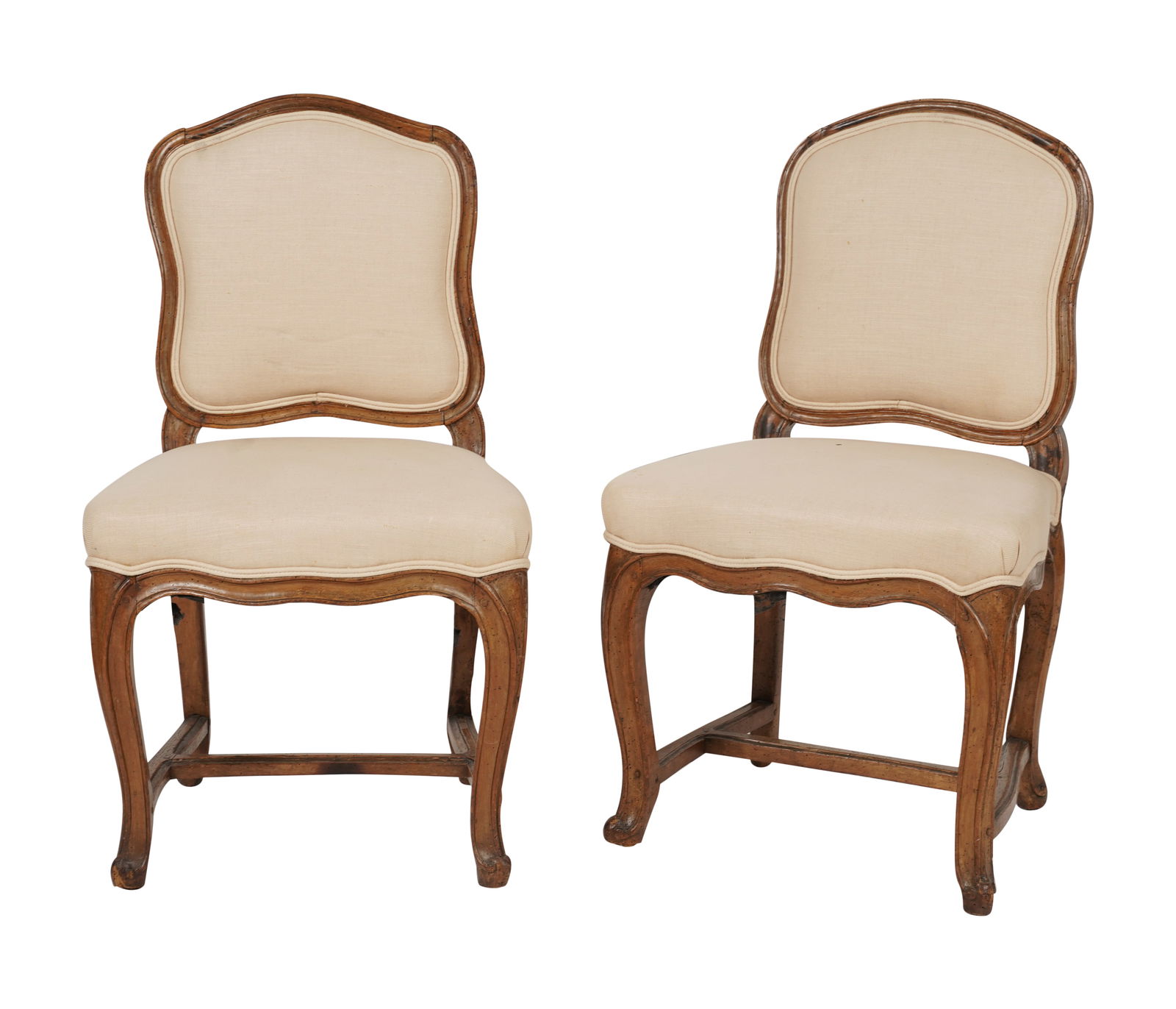 A Pair of French Regence Chairs: 18th century; covered with vintage cream-colored fabric 35 x 20 1/2 x 17 in. (88.9 x 52.1 x 43.2 cm.) Seat height: 18 in. (45.7 cm.) Provenance: Property from the collection of George Doan, Philadelph